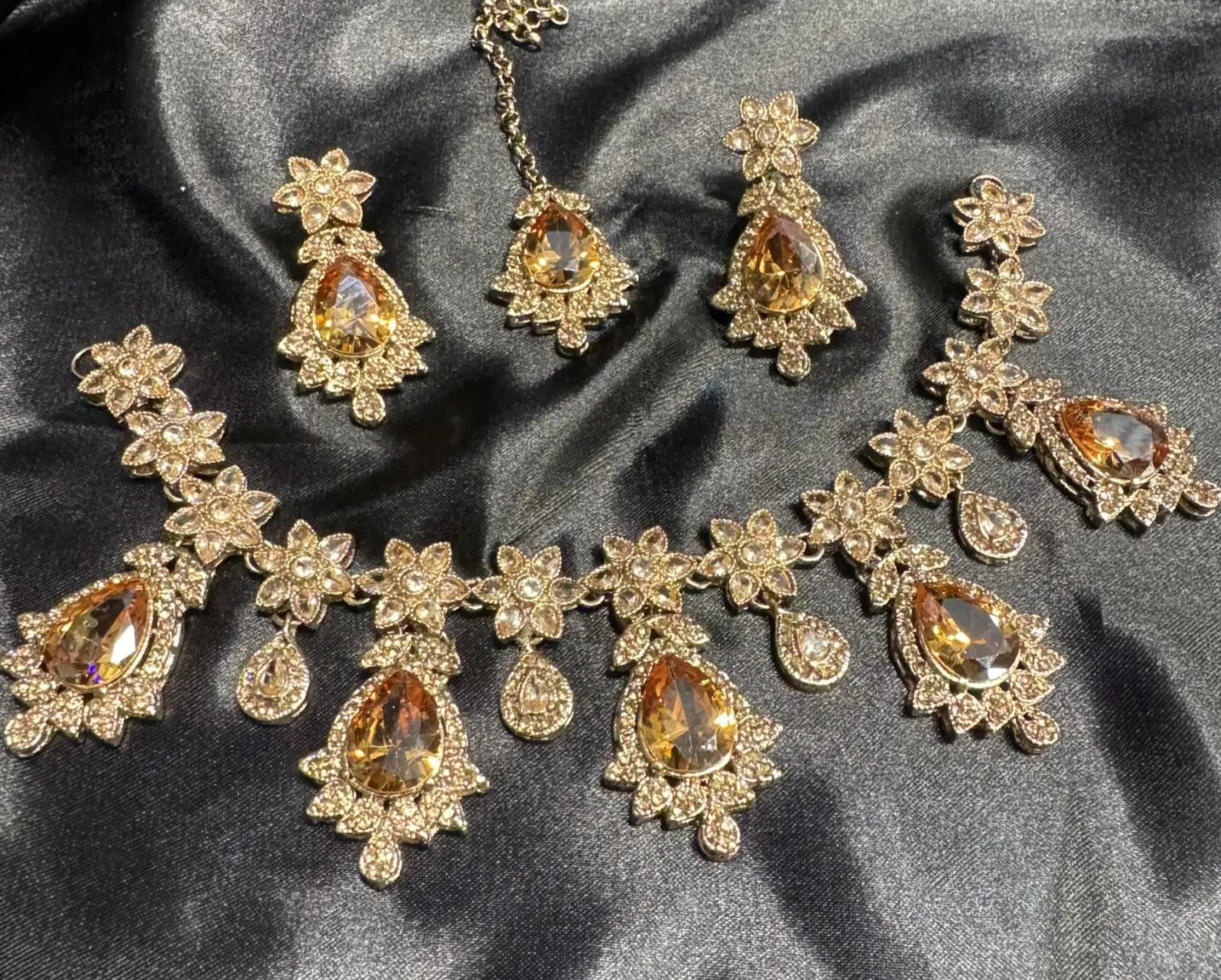 Champagne-colored bridal necklace set with CZ stones and gold floral detailing, includes matching earrings and teeka, handmade in Pakistan