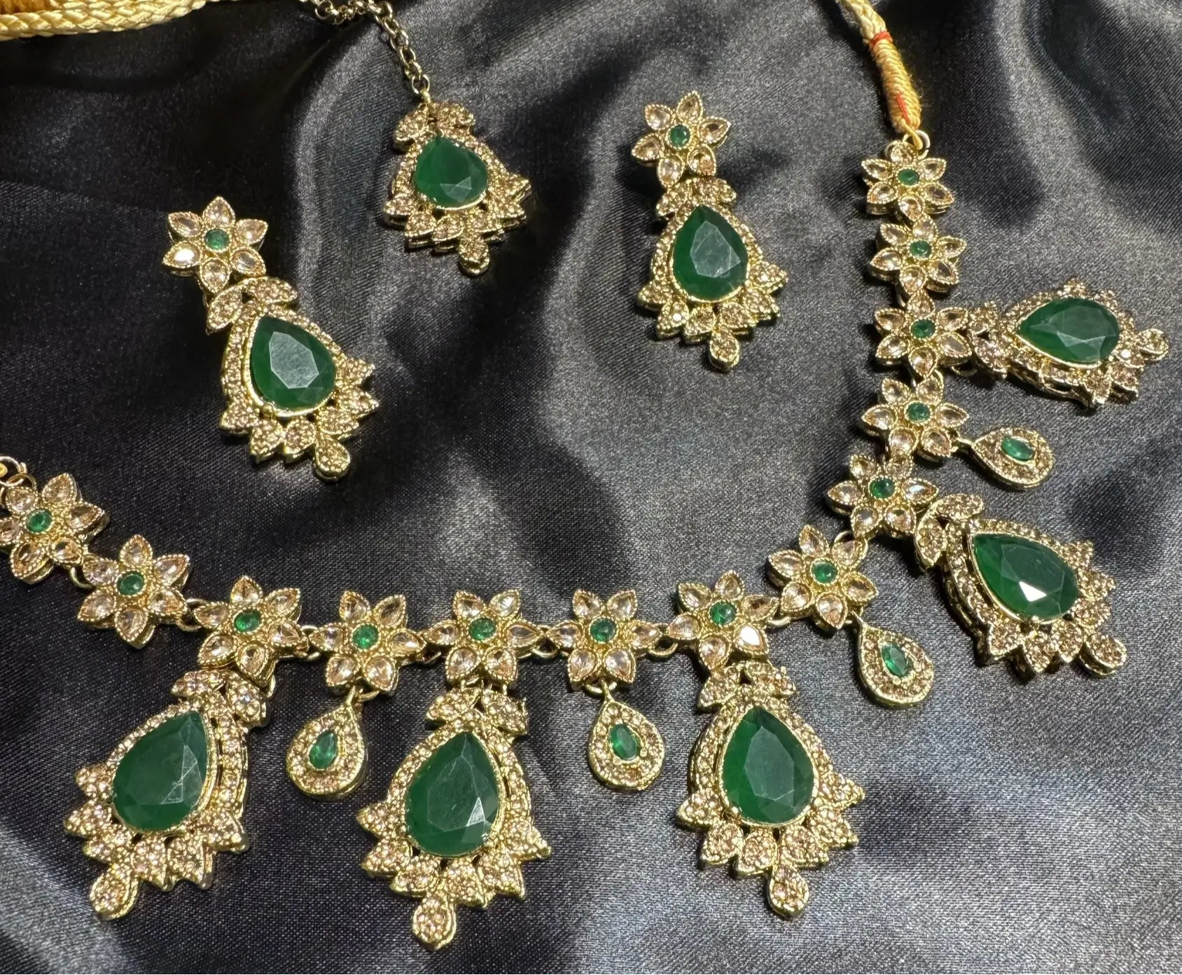 Traditional emerald green necklace set with gold floral accents, CZ stones, and matching earrings and teeka