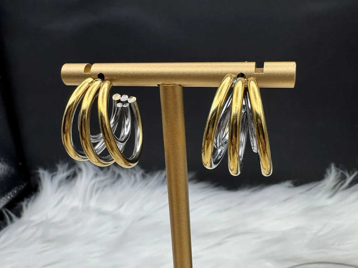 more closeup angle of gold half hoop earrings against a black background. Gold plated and stainless steel