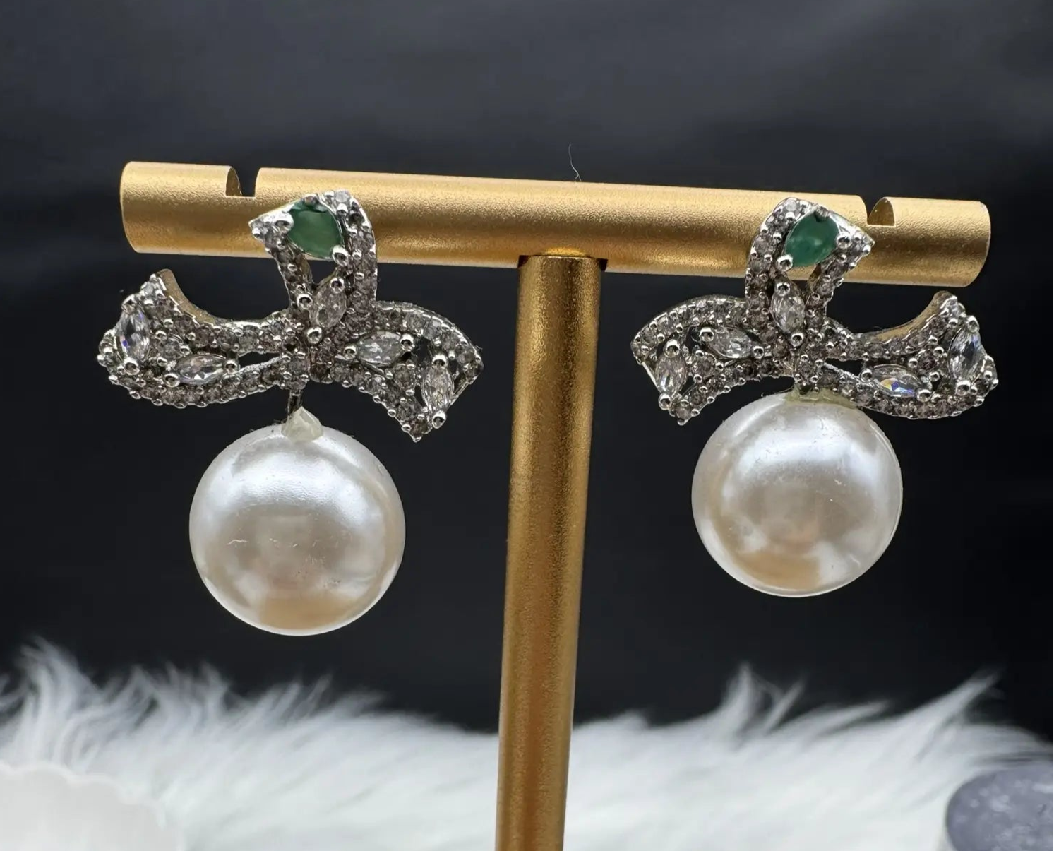 frontal view of pair of Pearl drop American diamonds earrings with teal colored stone