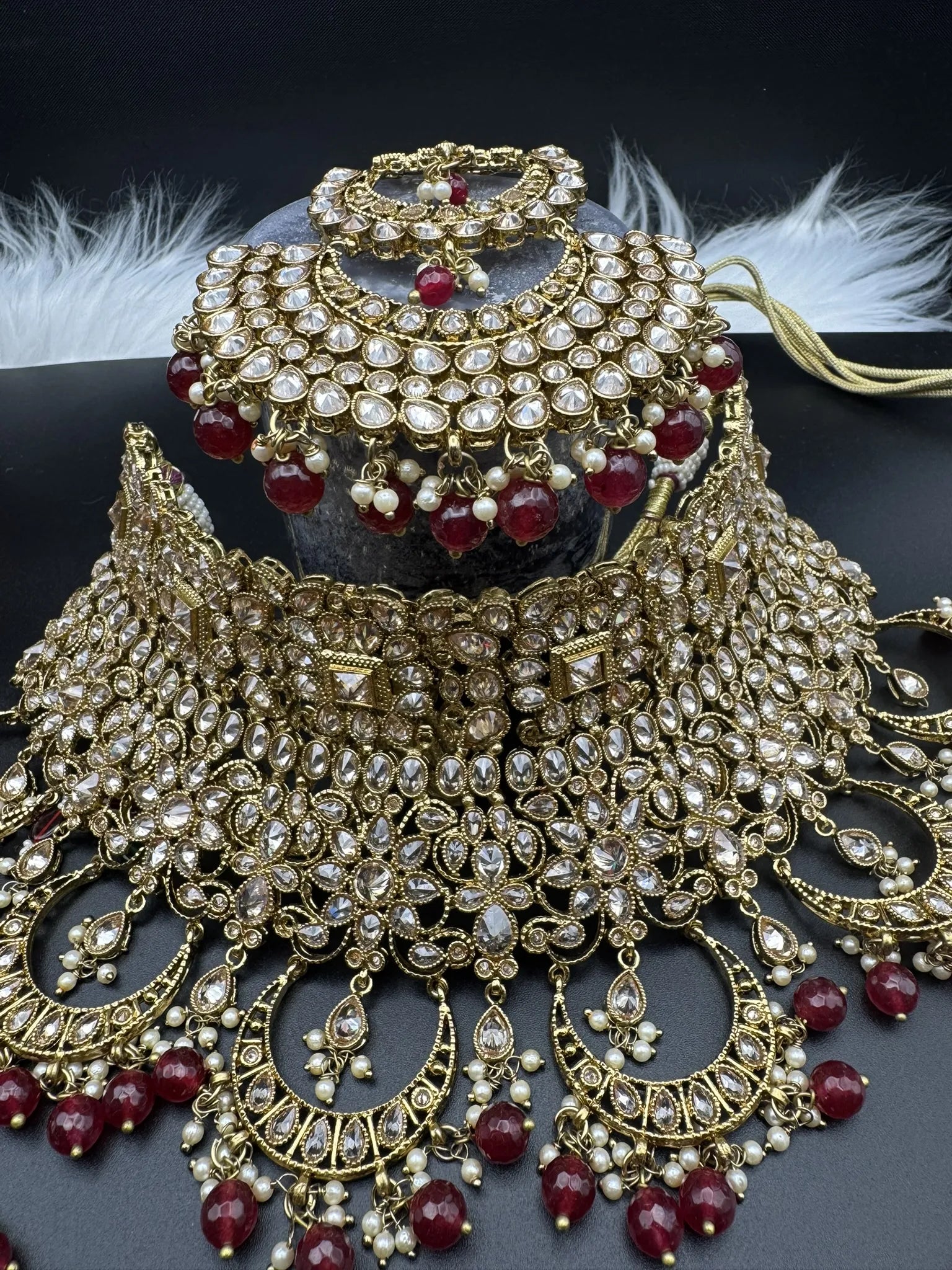 necklace focused view of exquisite gold-plated Indian bridal set with red accents, sparkling stones & matching earrings, teeka and a long traditional necklace. Waterproof & anti-tarnish.