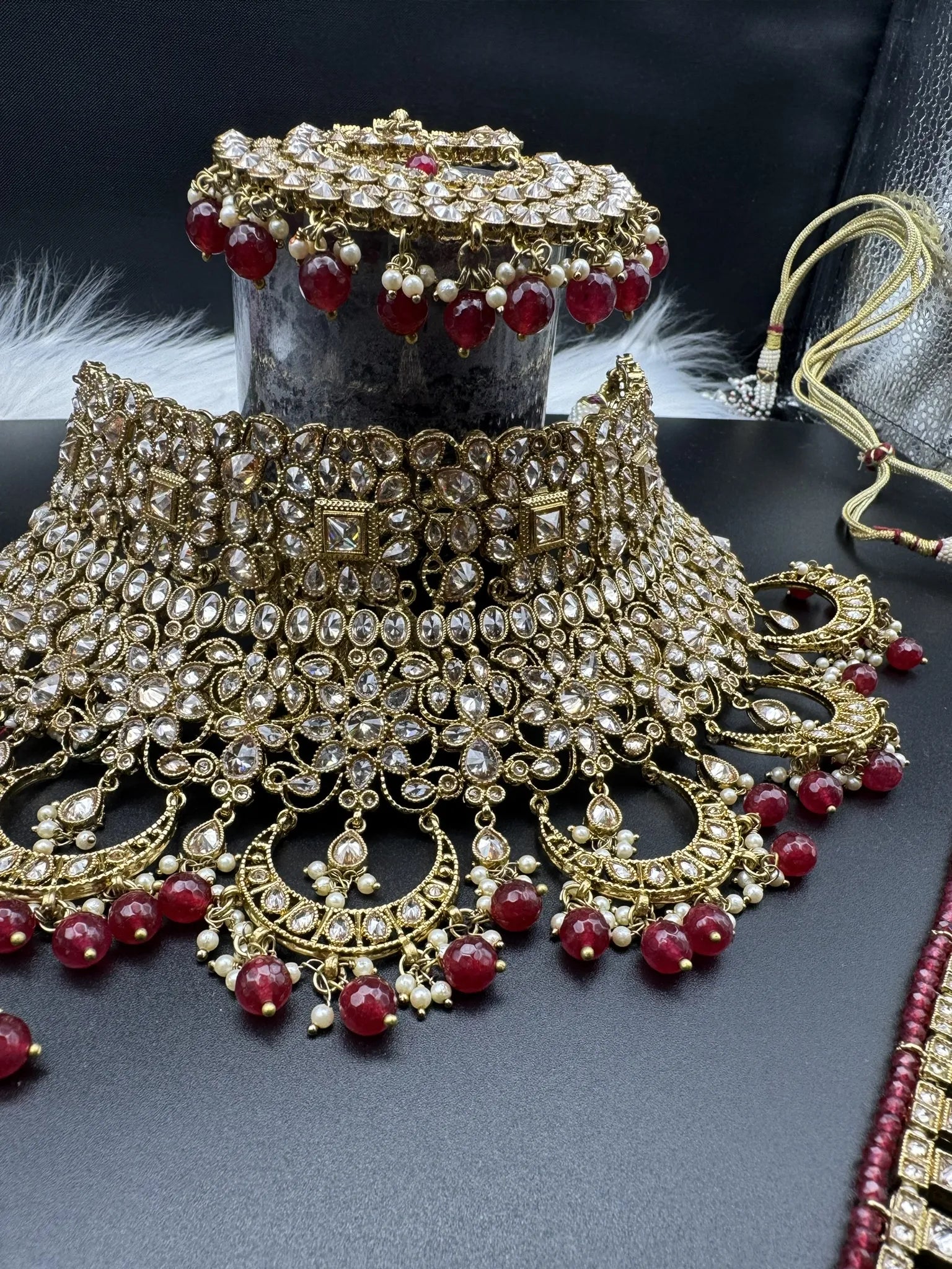 necklace focused view of exquisite gold-plated Indian bridal set with red accents, sparkling stones & matching earrings, teeka and a long traditional necklace. Waterproof & anti-tarnish.