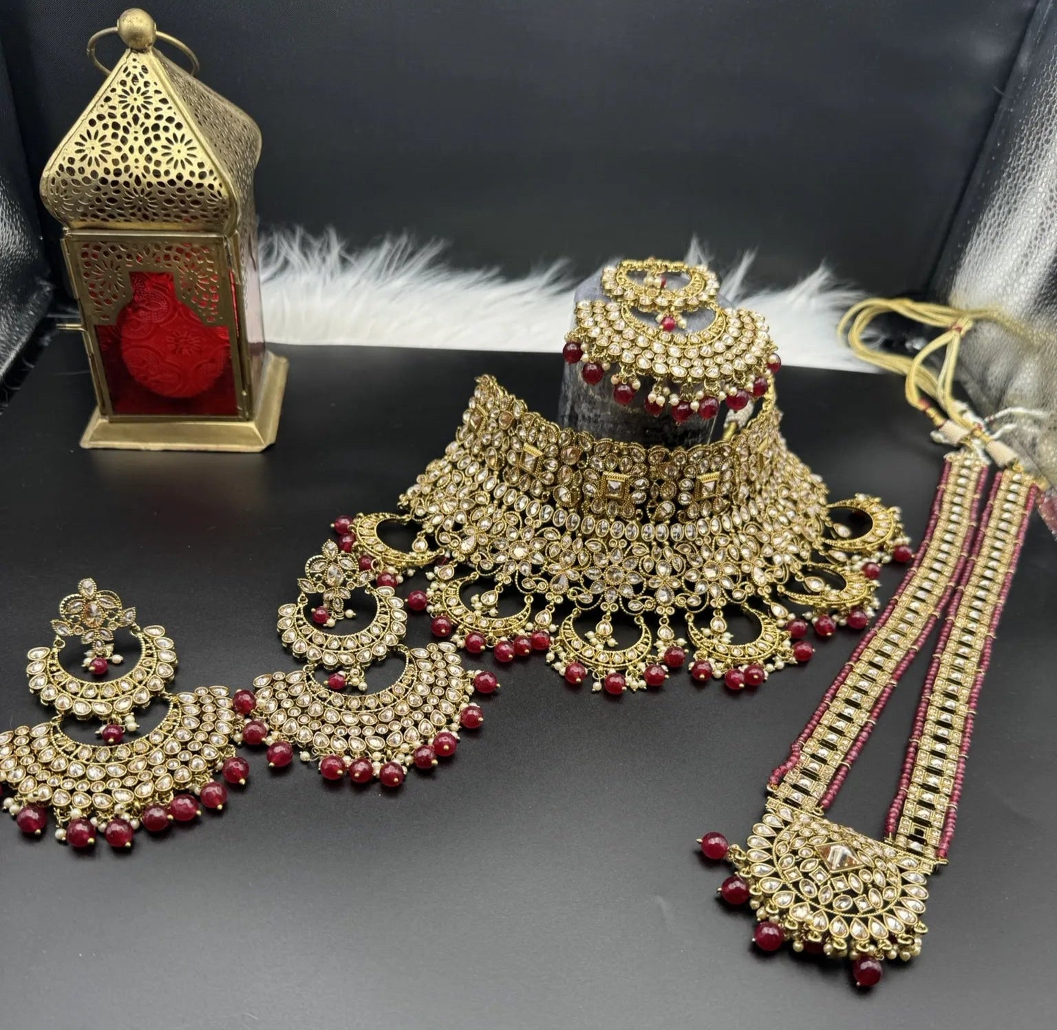 front view of exquisite gold-plated Indian bridal set with red accents, sparkling stones & matching earrings, teeka and a long traditional necklace. Waterproof & anti-tarnish.