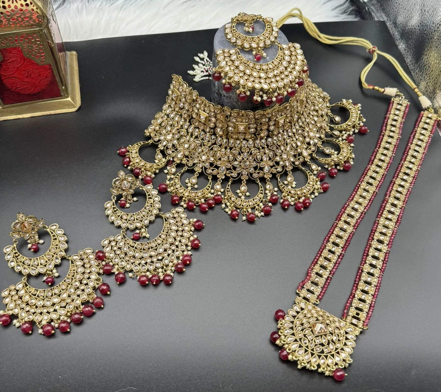 frontal view of exquisite gold-plated Indian bridal set with red accents, sparkling stones & matching earrings, teeka and a long traditional necklace. Waterproof & anti-tarnish.