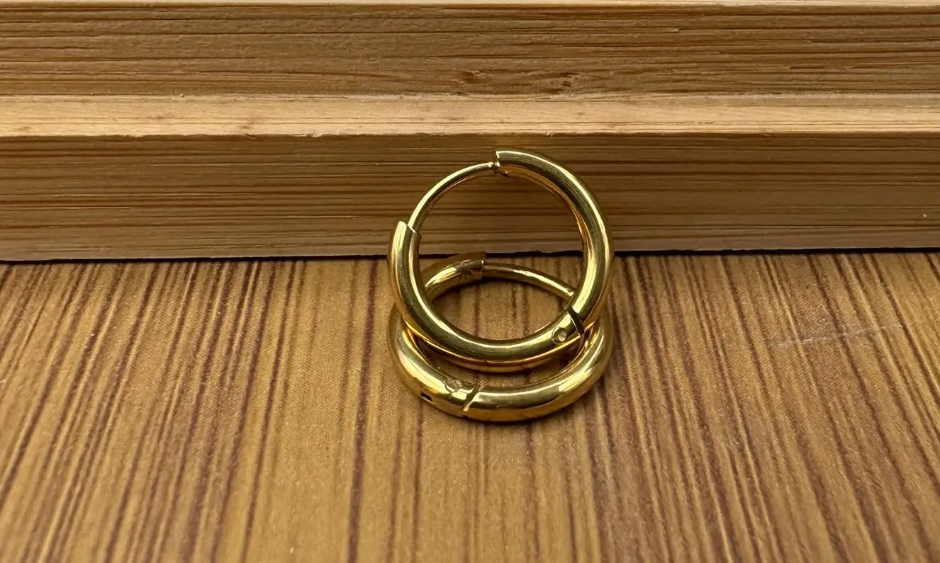 another angle of gold plated hoop earring on a wooden tray 