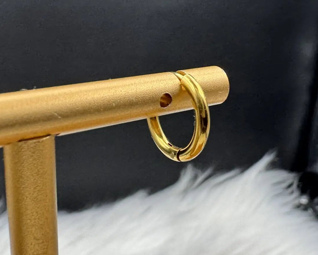 gold plated hoop earring with a black background