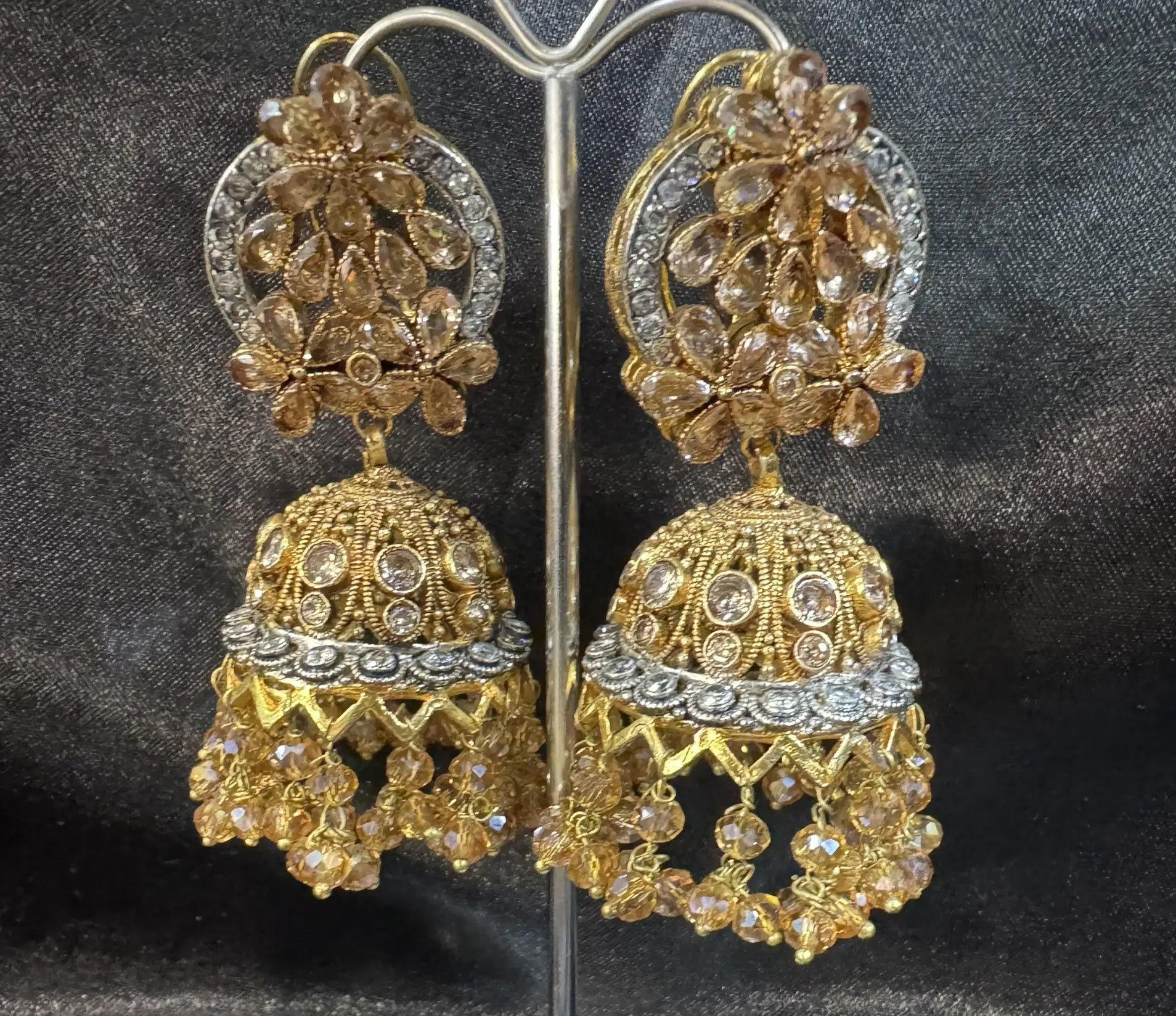 Gold and silver floral jhumkay on a dark background