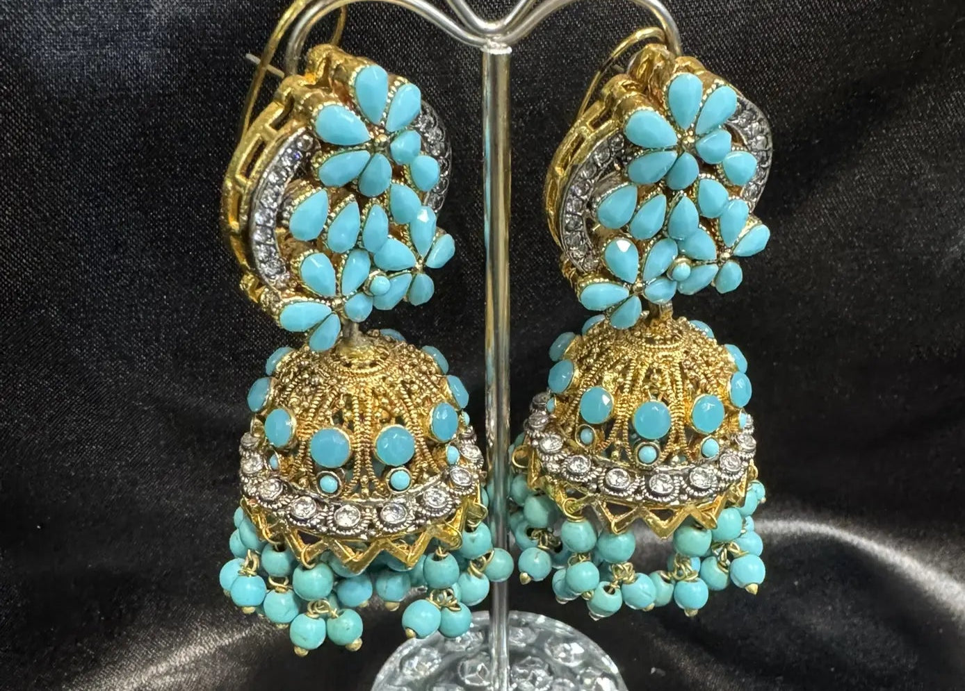 Pakistani design gold-plated jhumkay with turquoise colored gemstones and floral accents