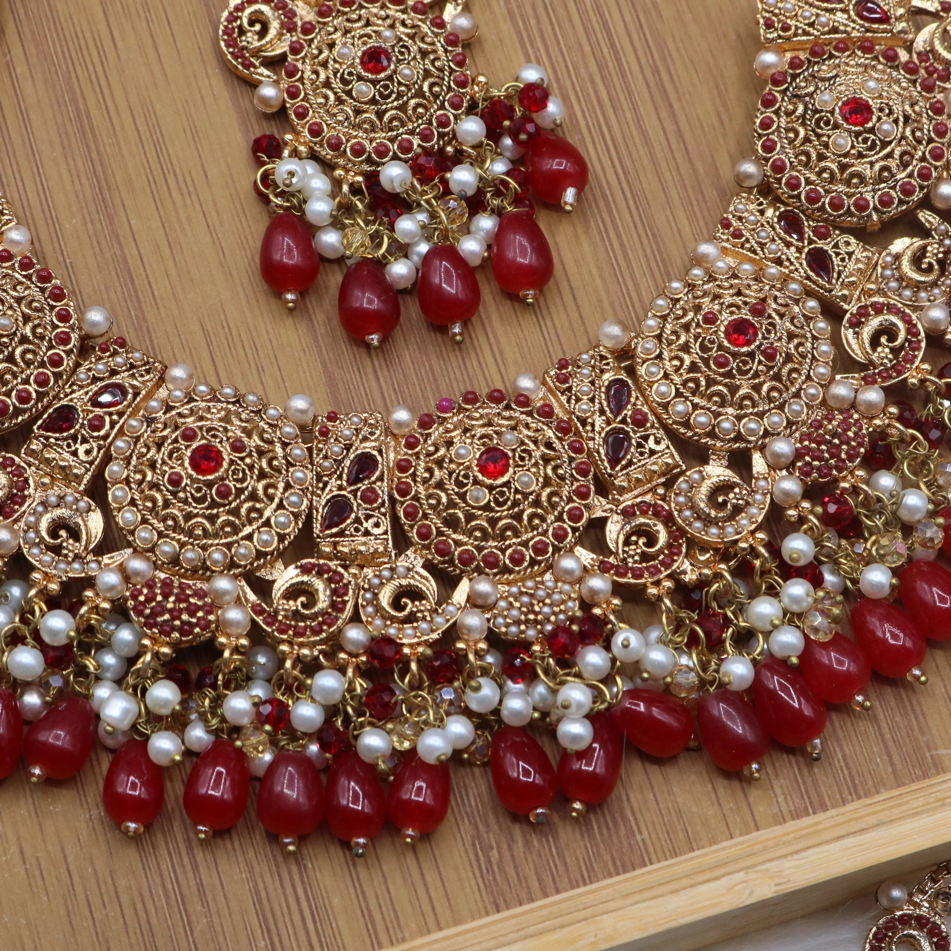 necklace view of Pakistani bridal necklace set with earrings, jhoomer and teeka in red and gold