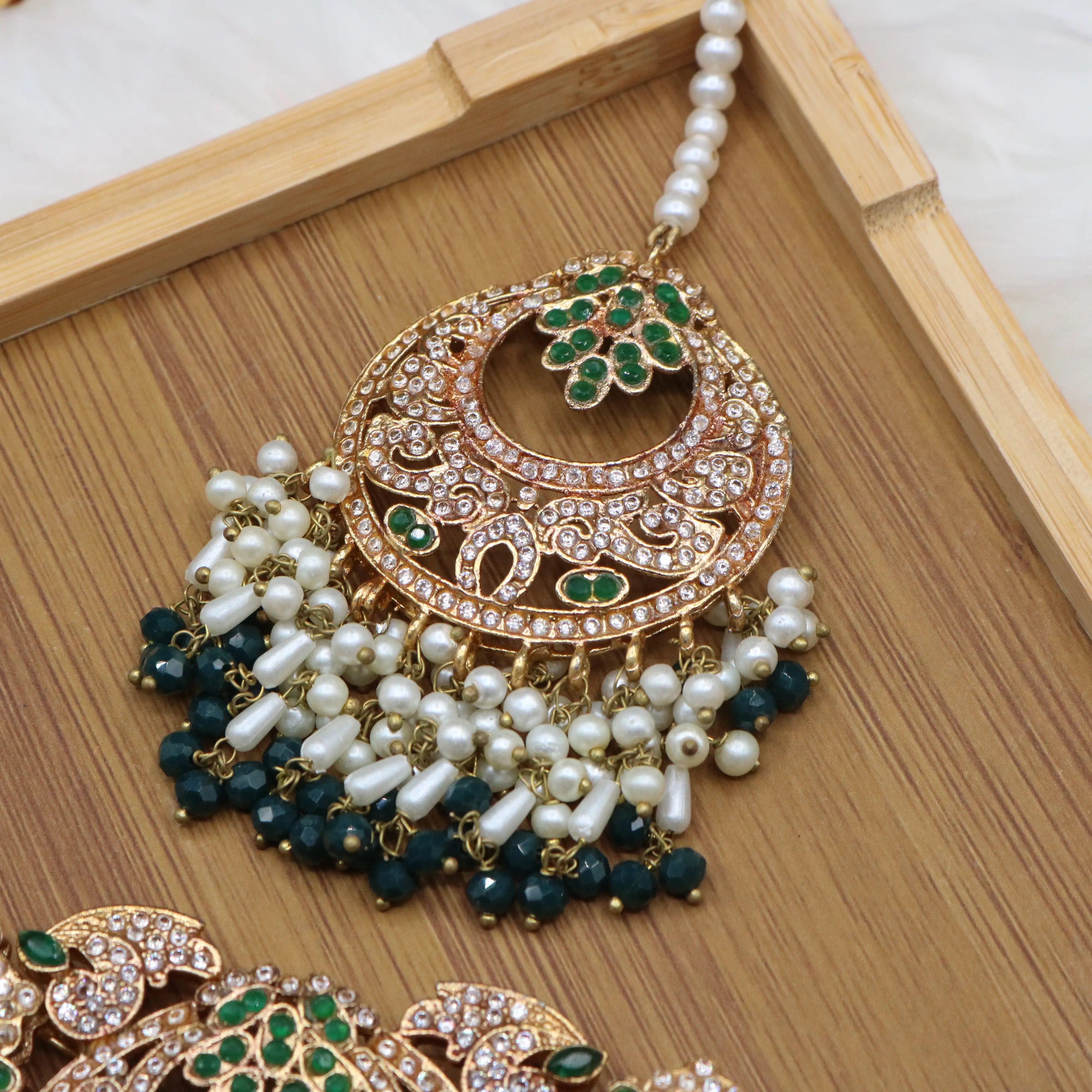teeka view of Emerald green bridal choker necklace with earrings and teeka in gold and pearls