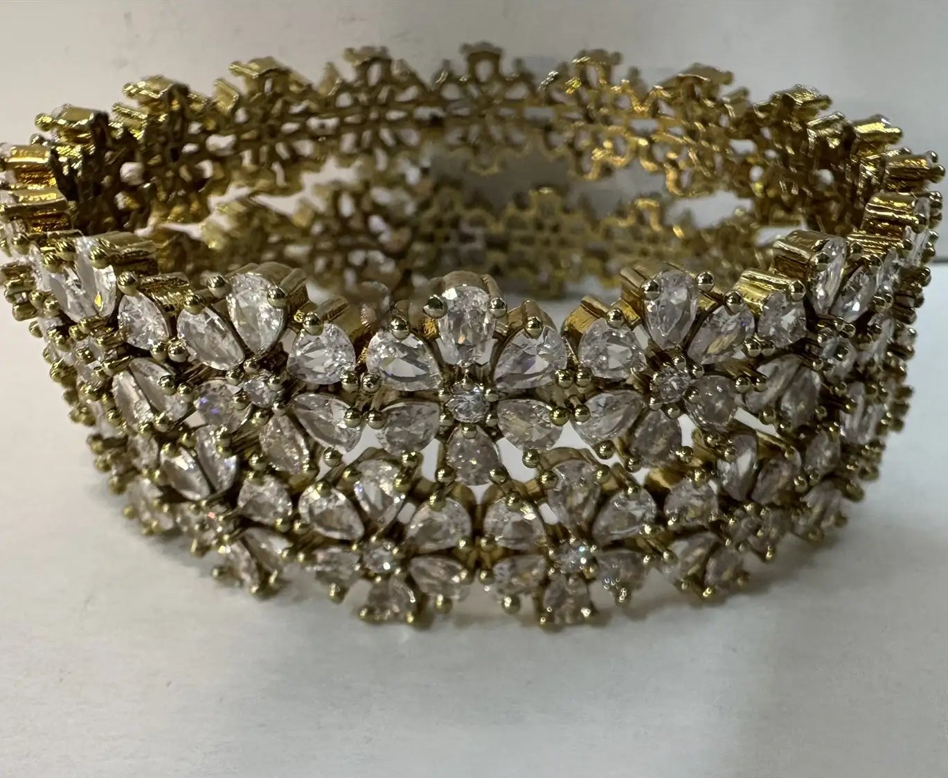 top view of 24k gold plated floral pattern bangle set with antique polish for a lasting shine on a white background