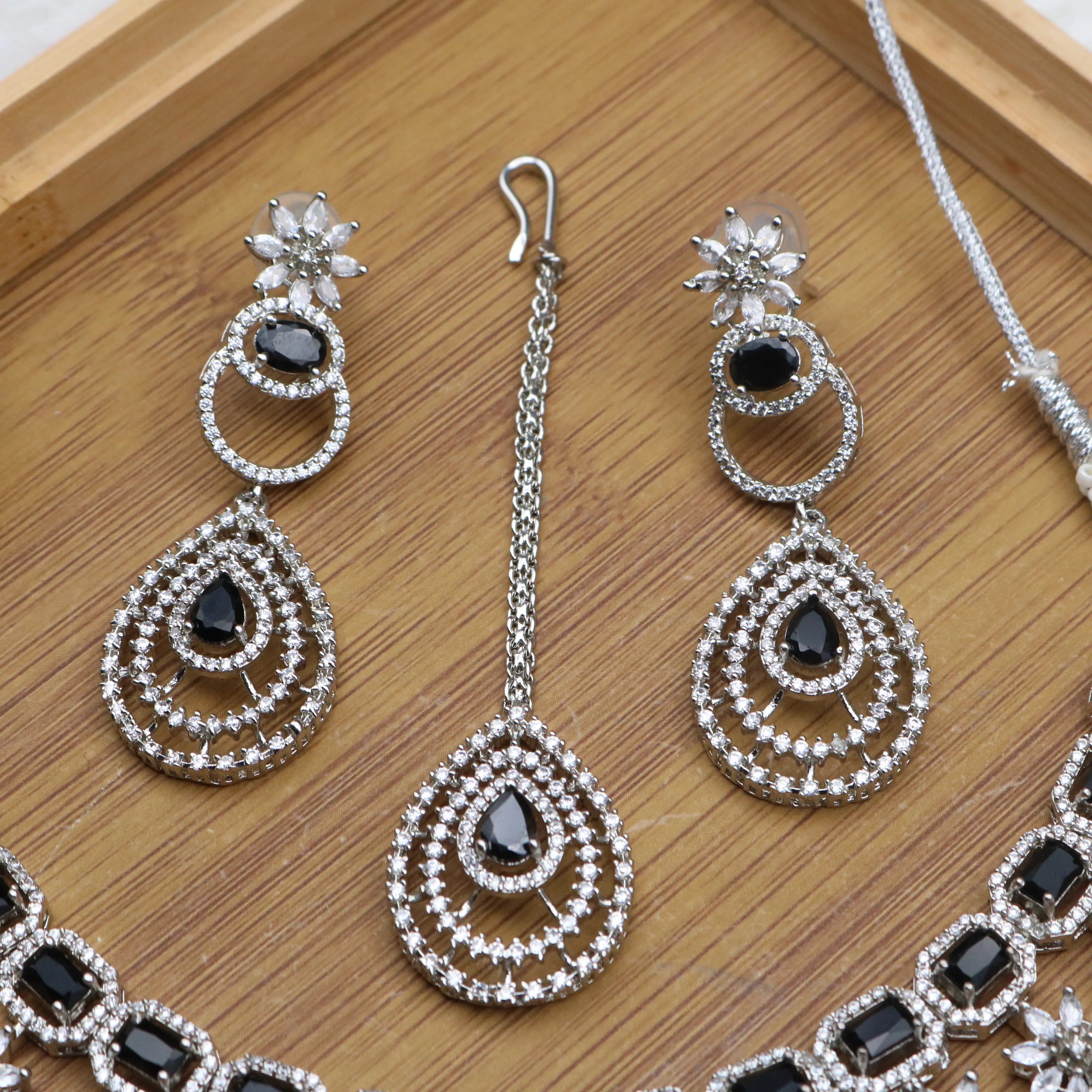 earrings and teeka view of Partywear necklace set in black stones and American diamonds