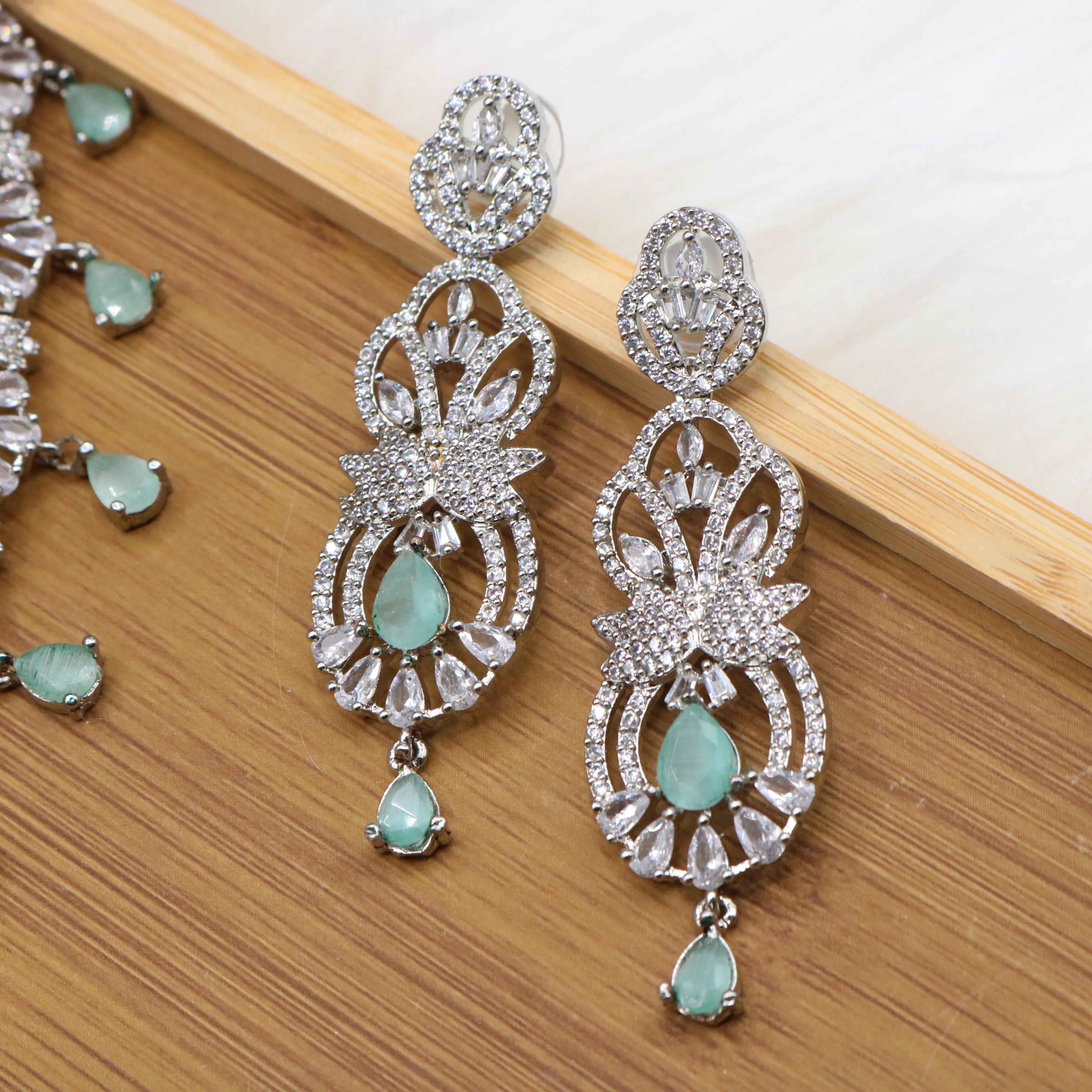 earrings view of Silver finish partywear jewelry set with American diamonds and teal gemstones