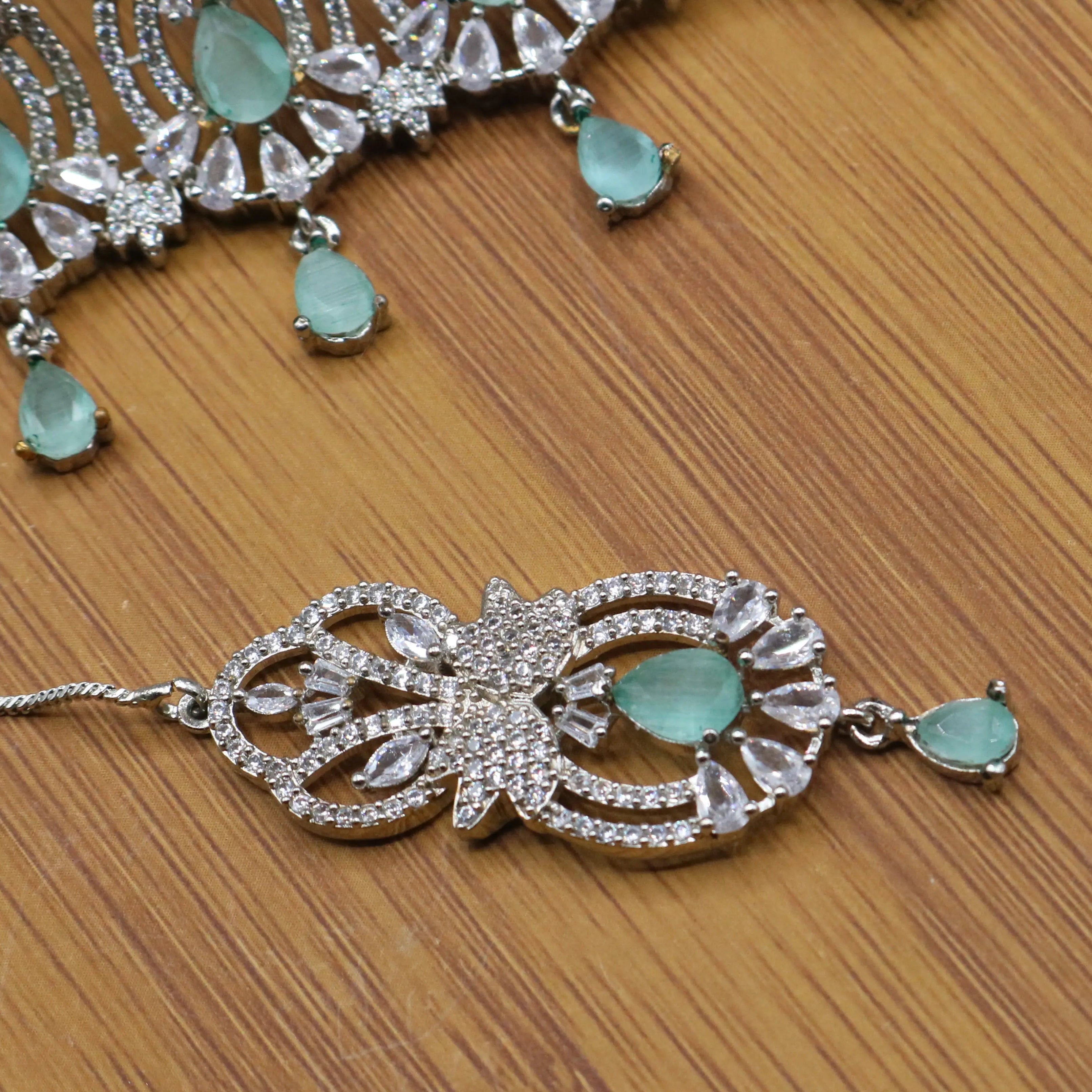 teeka view of Silver finish partywear jewelry set with American diamonds and teal gemstones