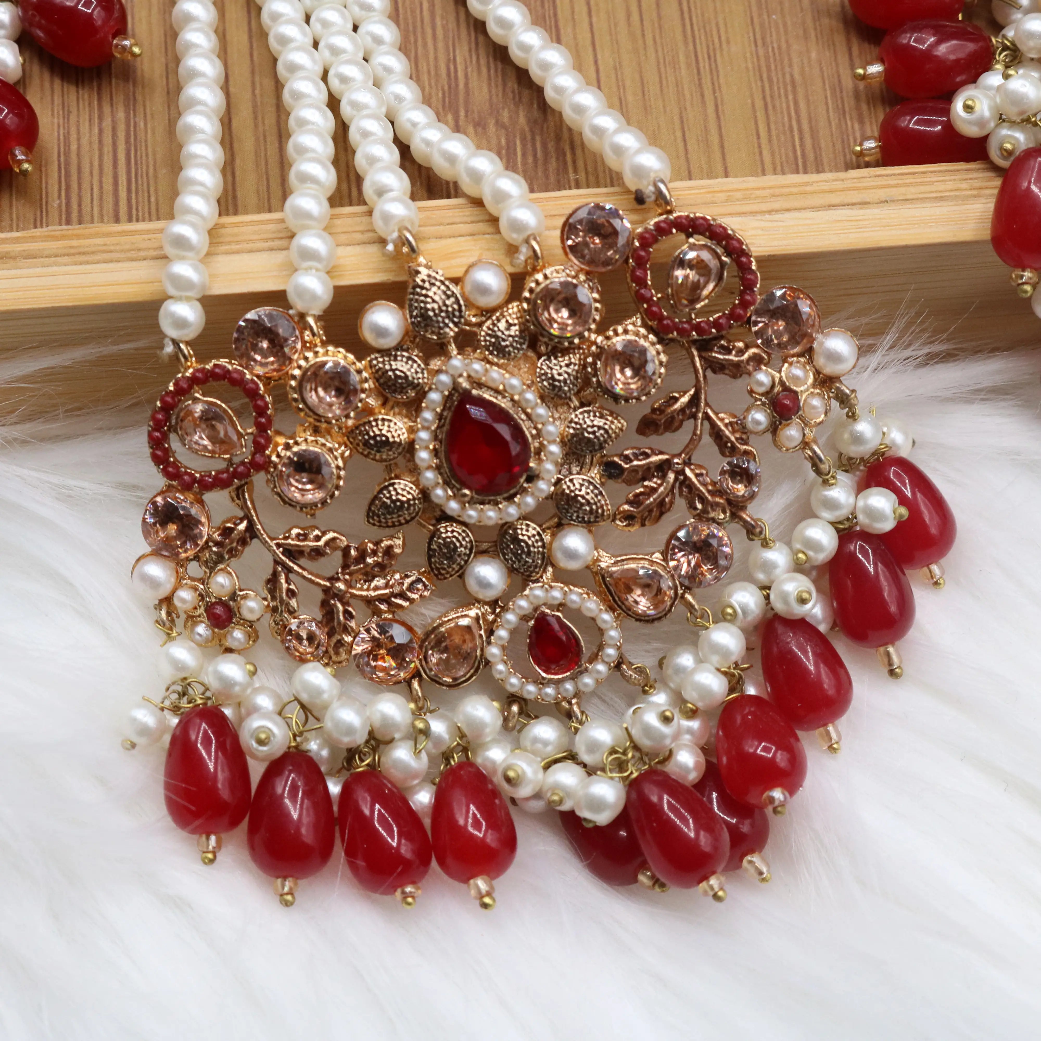 jhoomer view of Pakistani wedding choker set with red stones, gold plating and pearls, earrings, teeka & jhoomer