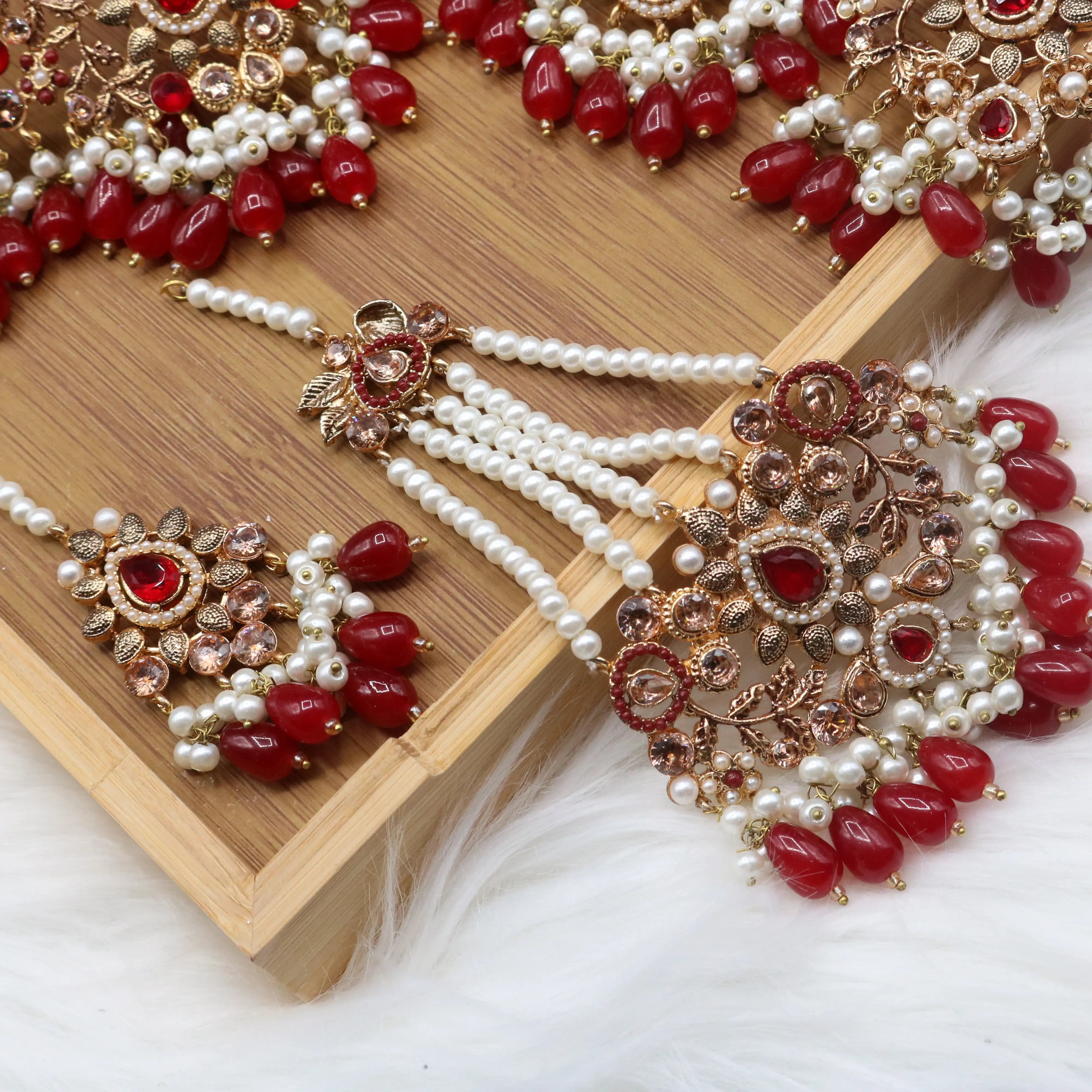 teeka and jhoomer view of Pakistani wedding choker set with red stones, gold plating and pearls, earrings, teeka & jhoomer