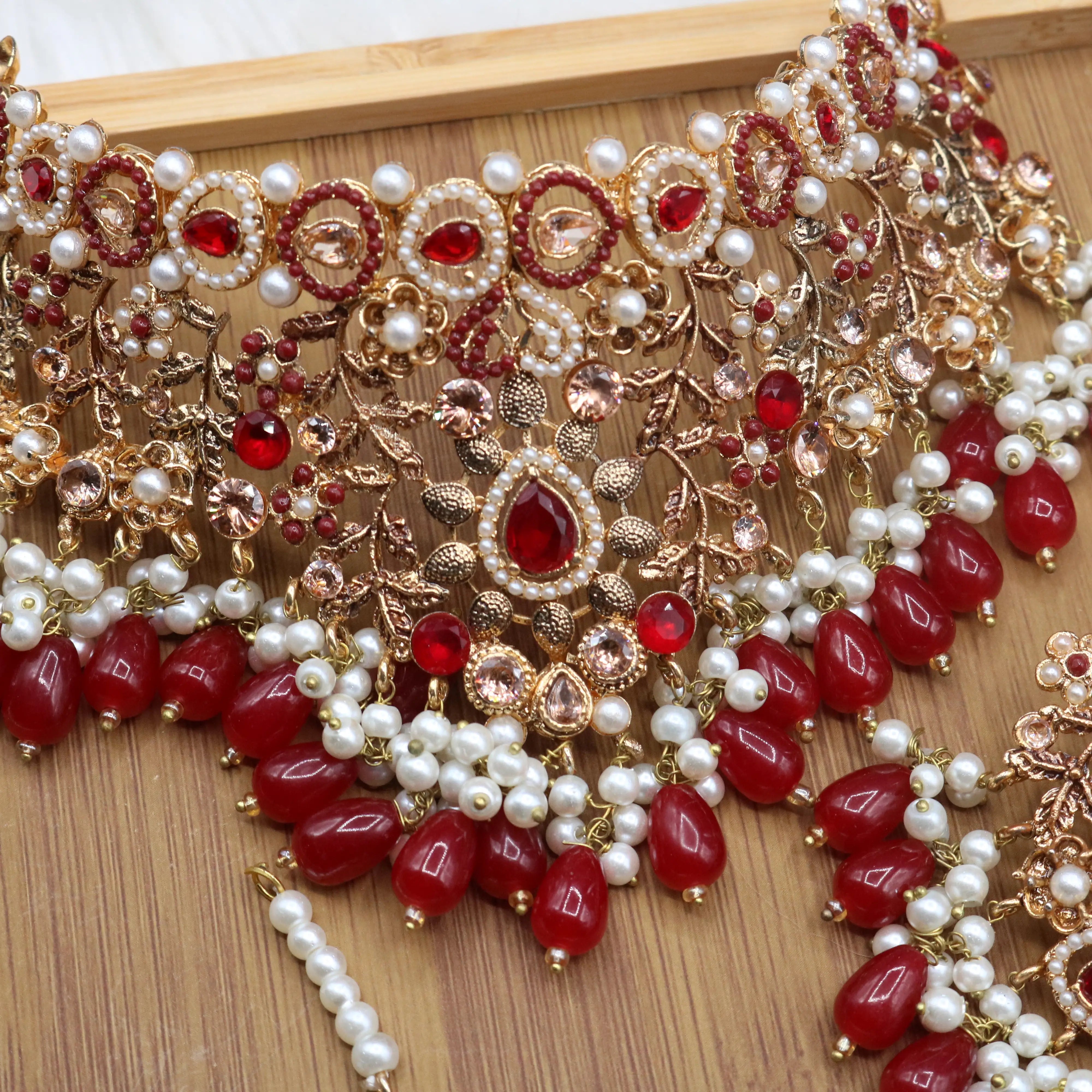 necklace view of Pakistani wedding choker set with red stones, gold plating and pearls, earrings, teeka & jhoomer