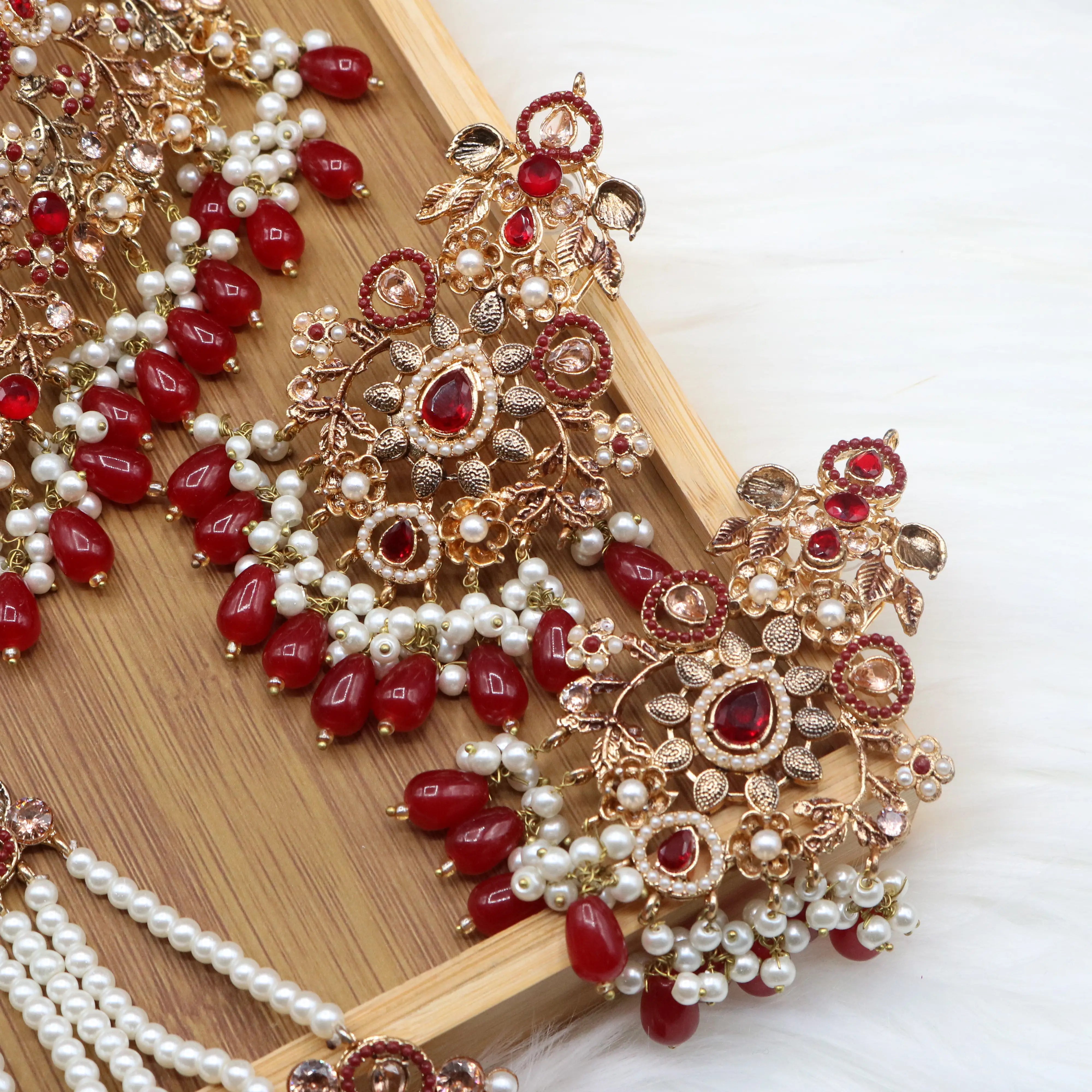 earrings view of Pakistani wedding choker set with red stones, gold plating and pearls, earrings, teeka & jhoomer