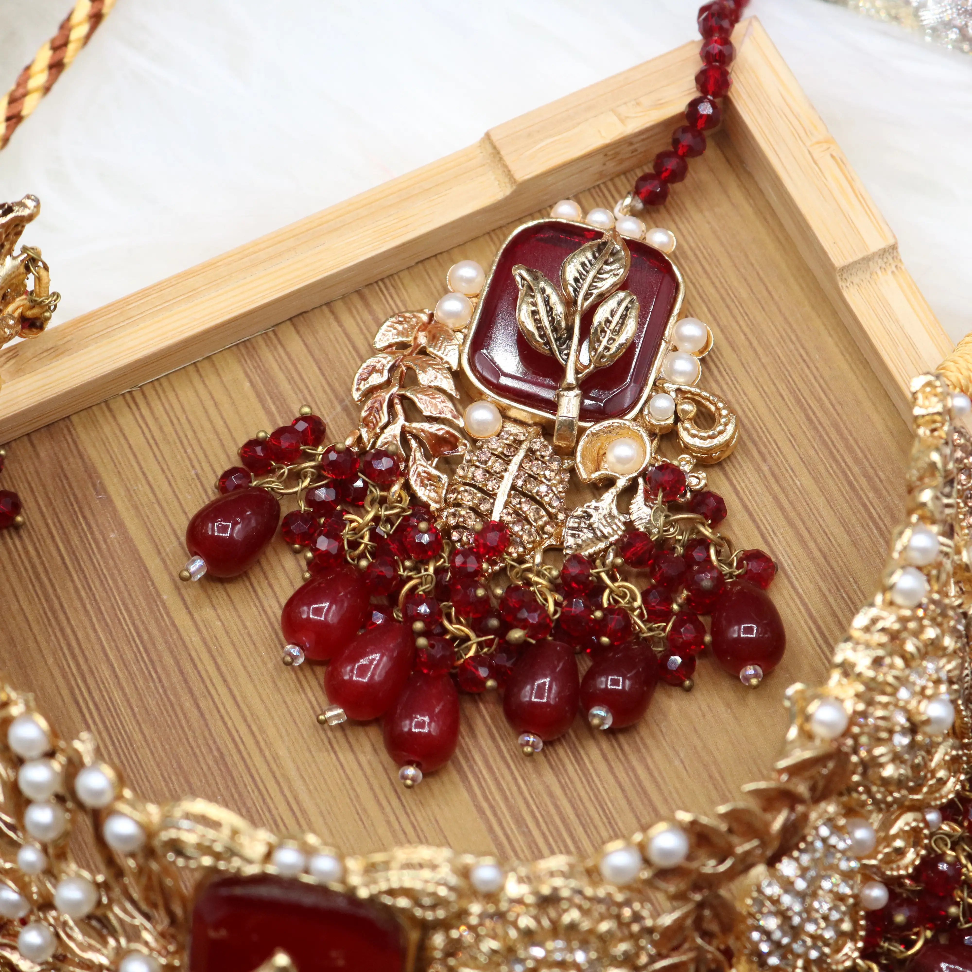 teeka view of Red Pakistani bridal choker necklace with matching mala set. Gold-plated bridal set with American diamonds and red stones