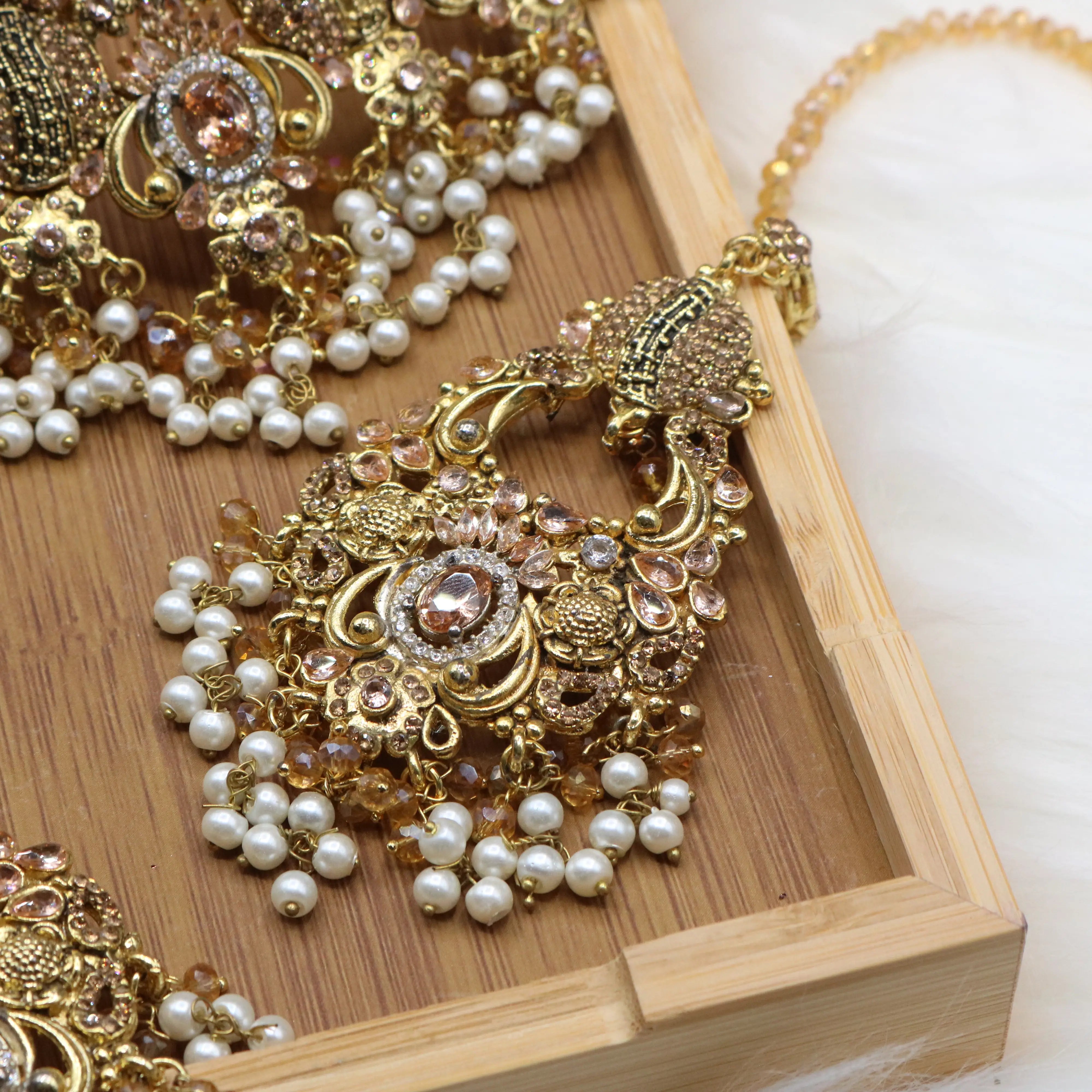 teeka view of Peach Pakistani bridal choker set with pearls and gold-plating. 