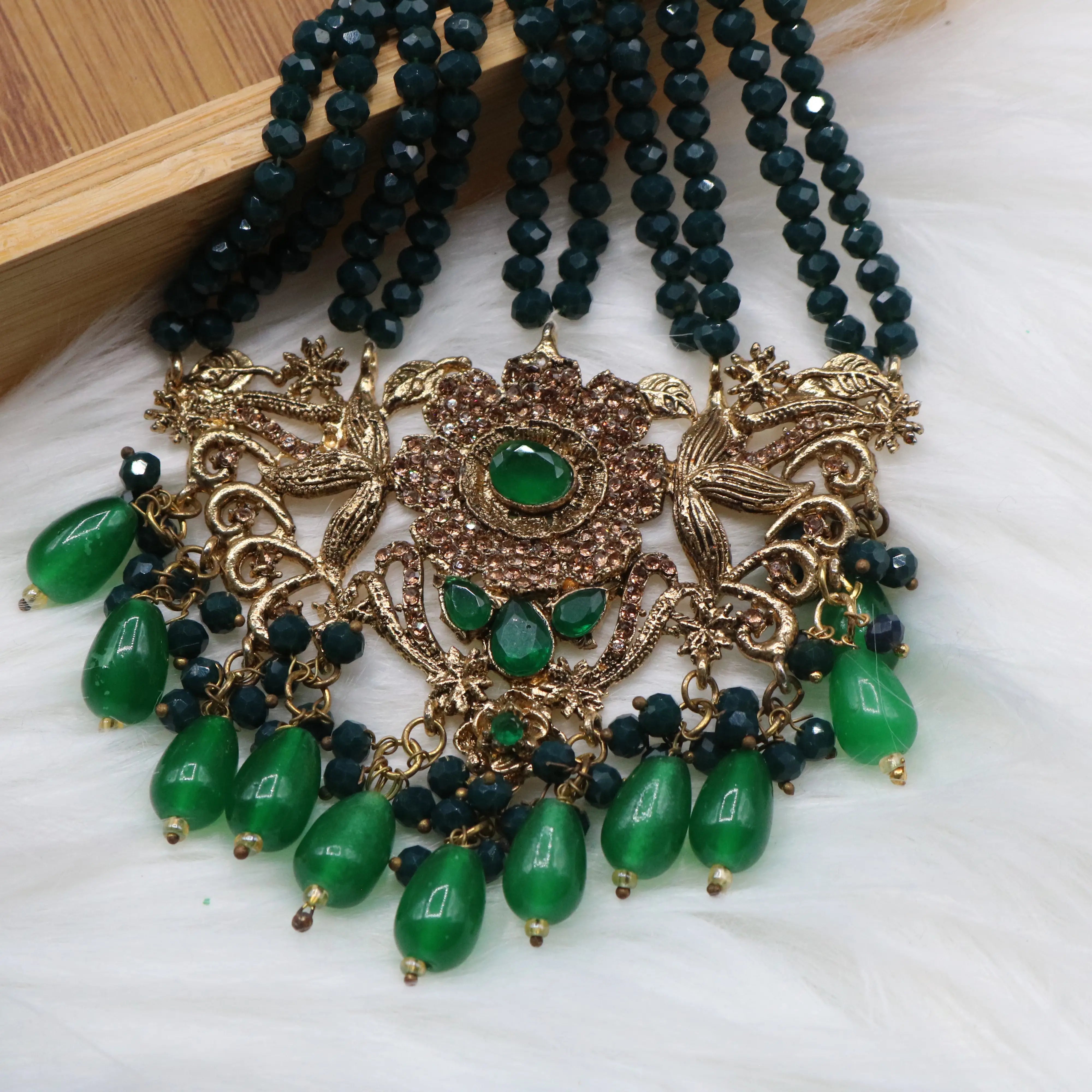 jhoomer view of Pakistani bridal jewelry set with green stones and teeka