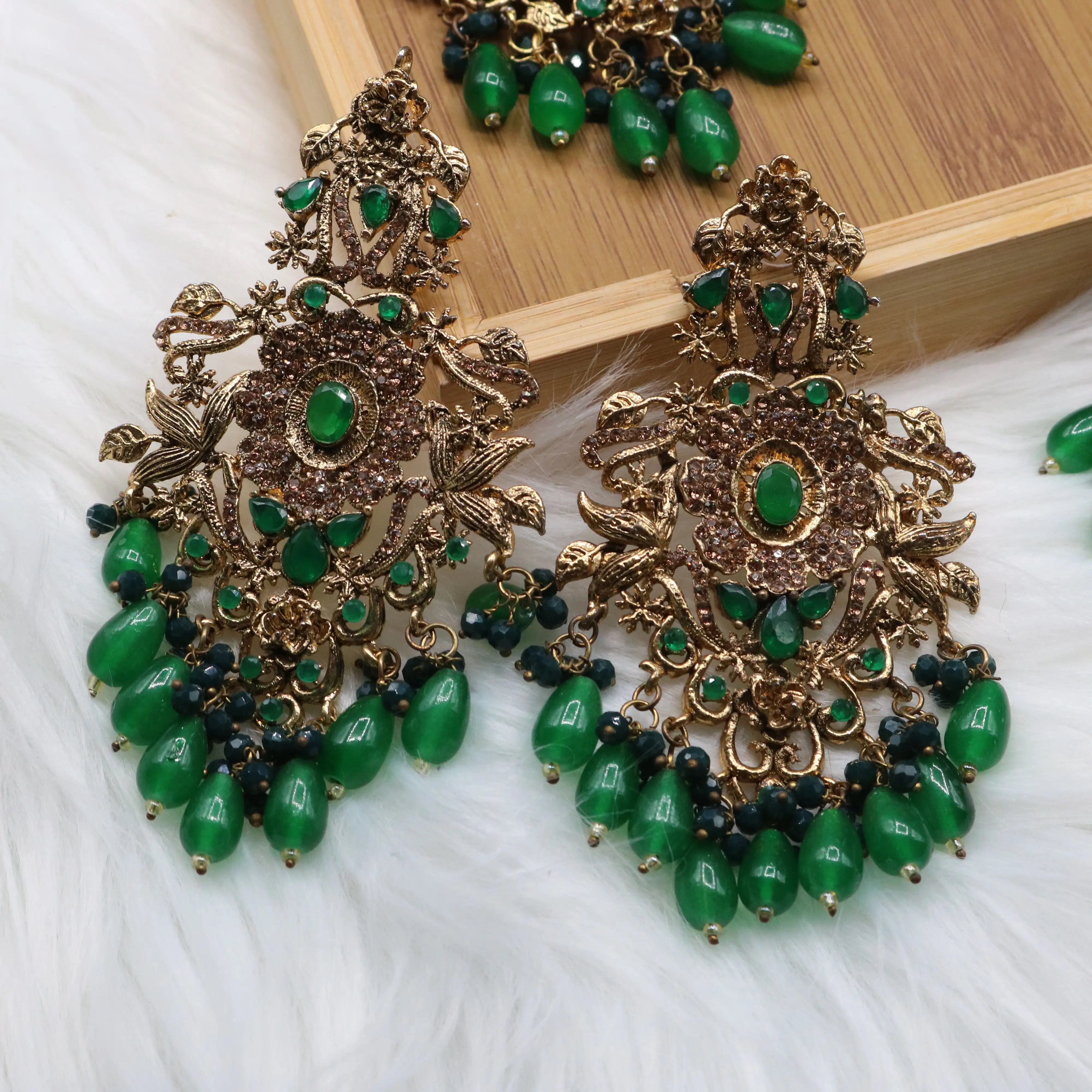 earrings view of Pakistani bridal jewelry set with green stones and teeka