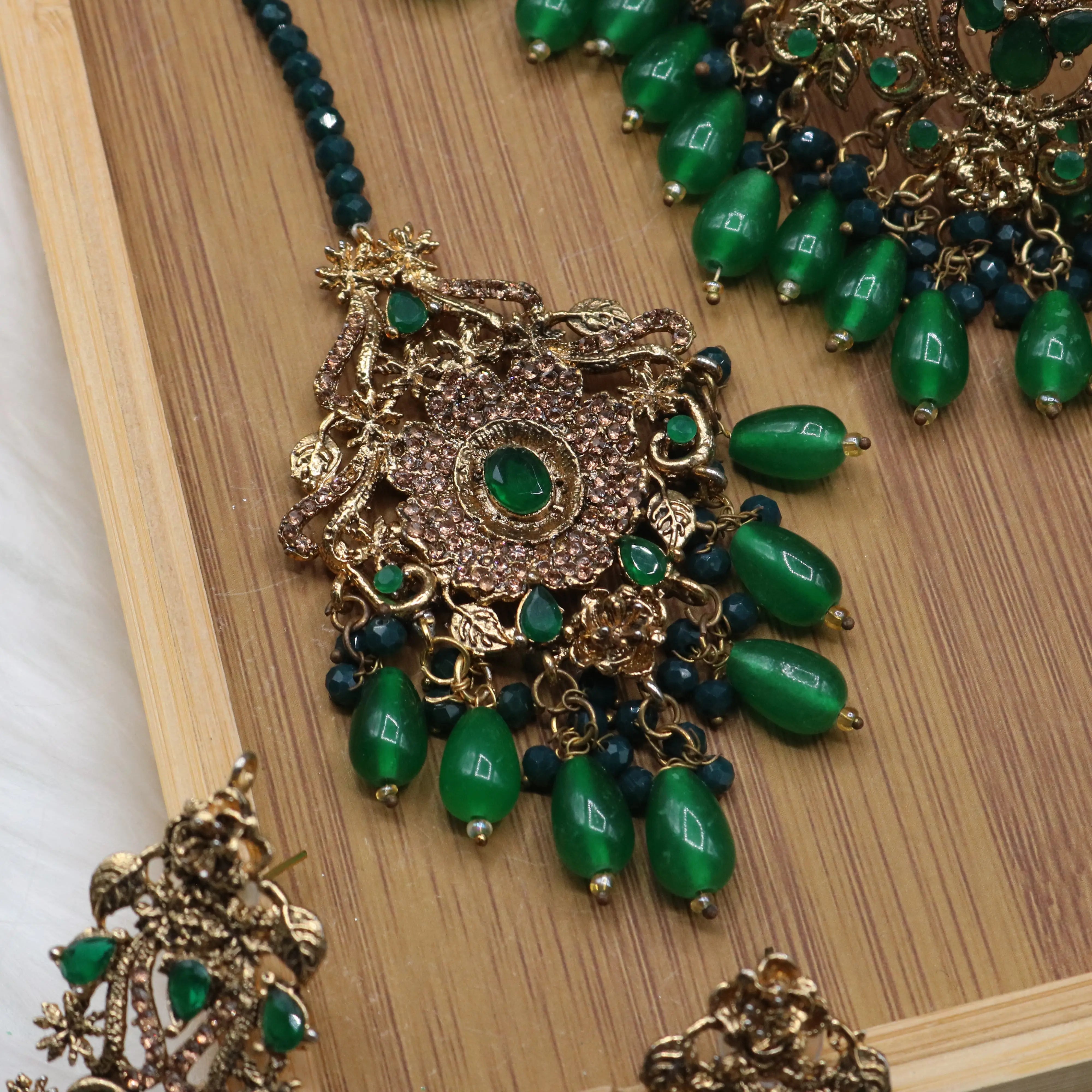 teeka view of Pakistani bridal jewelry set with green stones and teeka