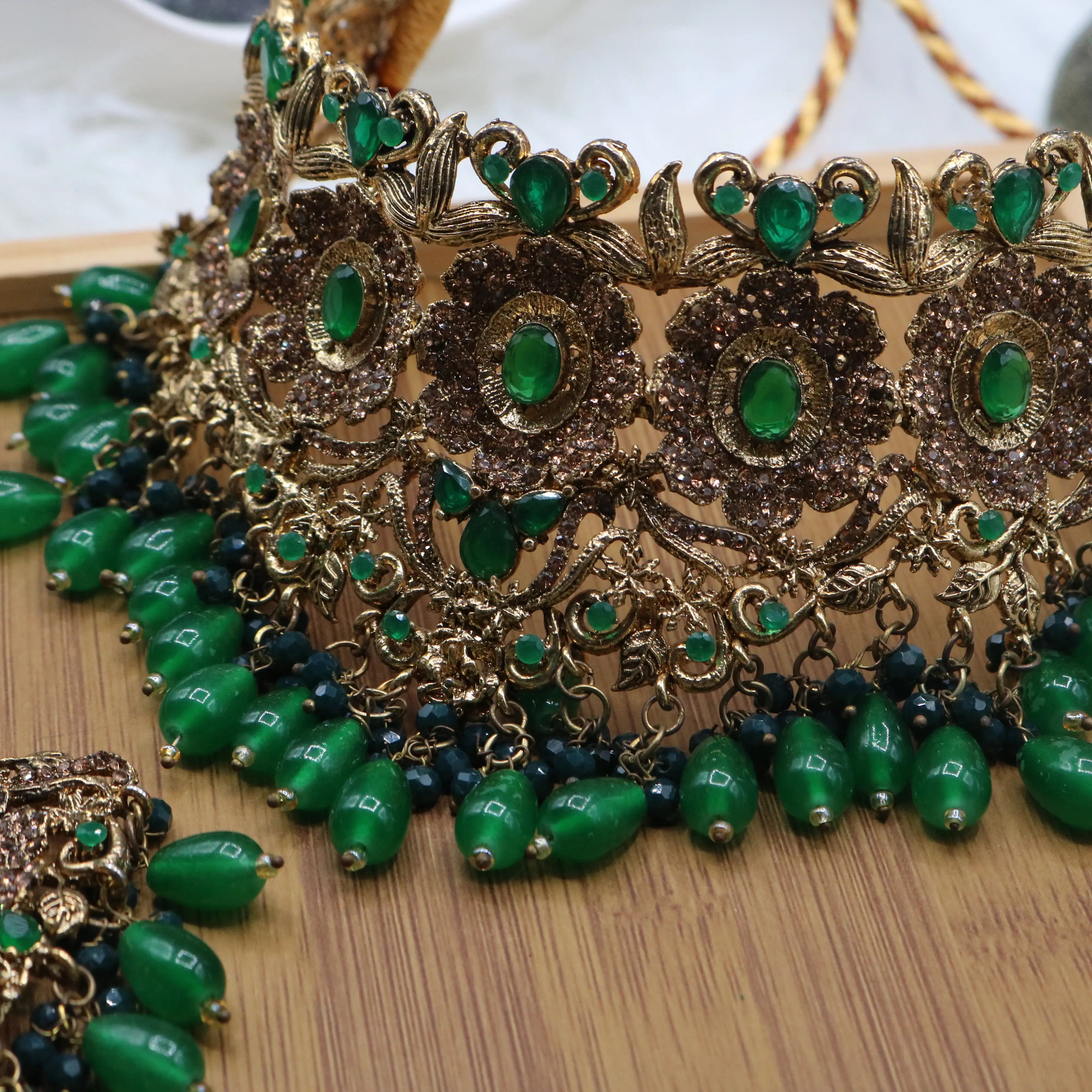 necklace view of Pakistani bridal jewelry set with green stones and teeka