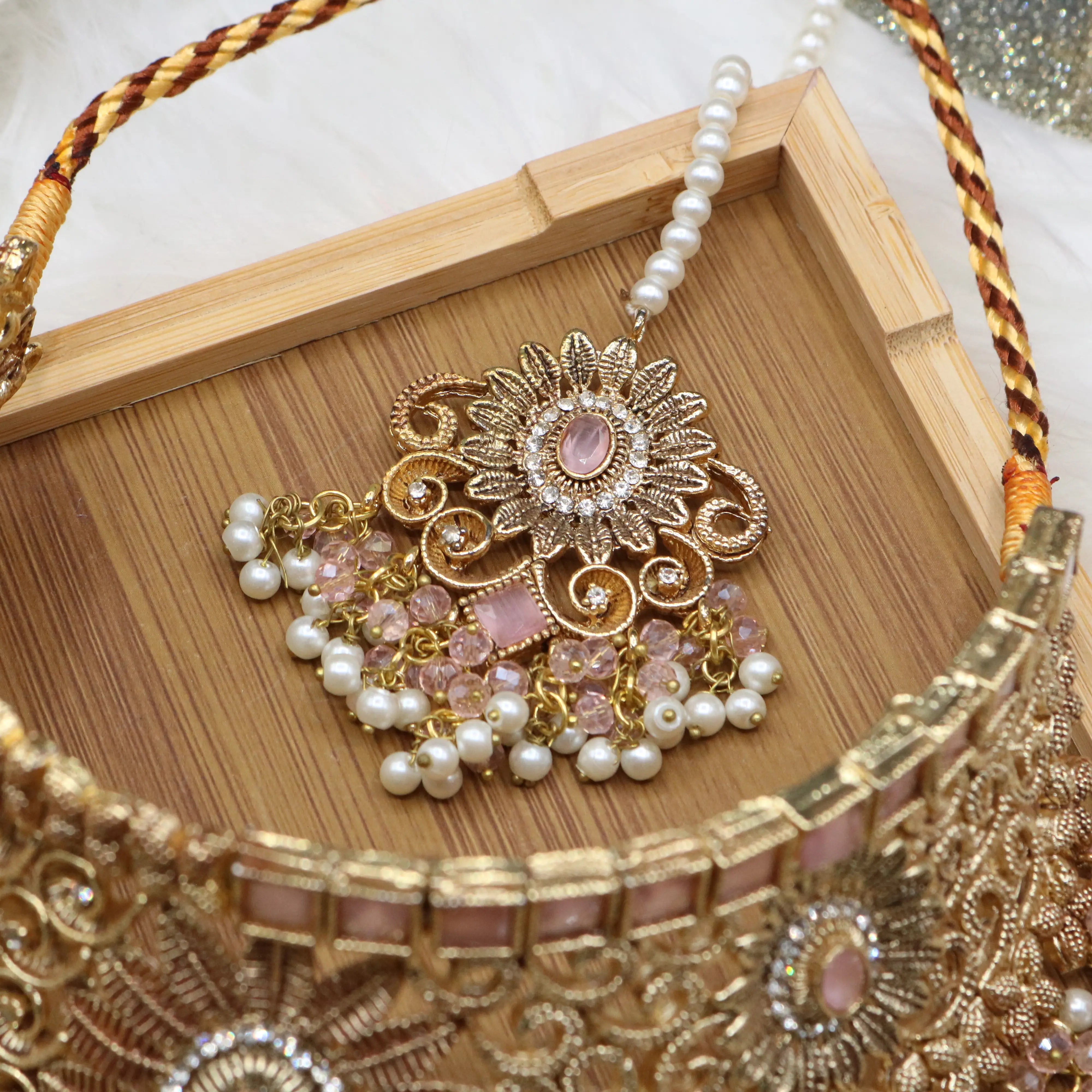 teeka view of Pink and pearl 6-piece Pakistani bridal jewelry set with choker, long maala, earrings, teeka & jhoomer