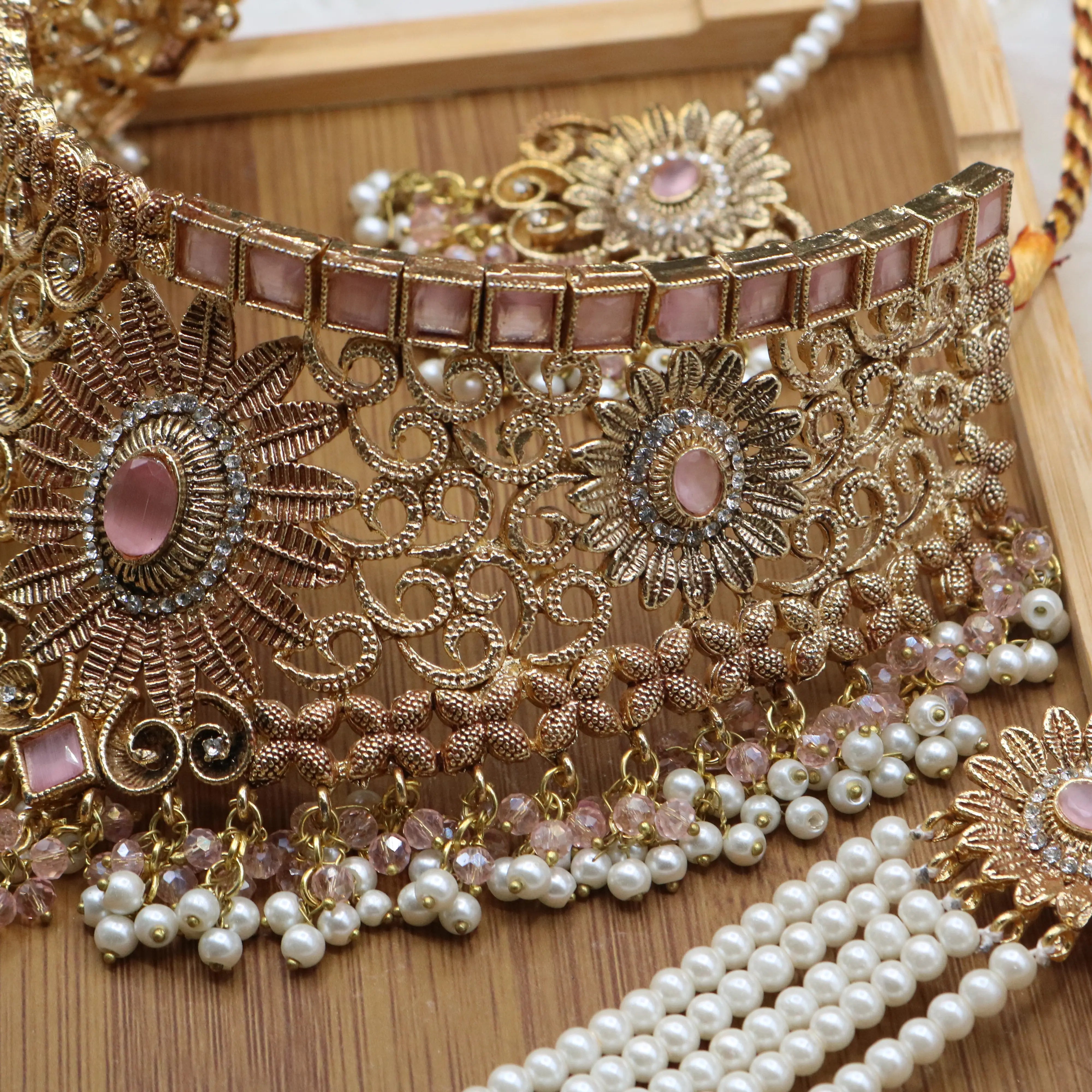 closer necklace view of Pink and pearl 6-piece Pakistani bridal jewelry set with choker, long maala, earrings, teeka & jhoomer