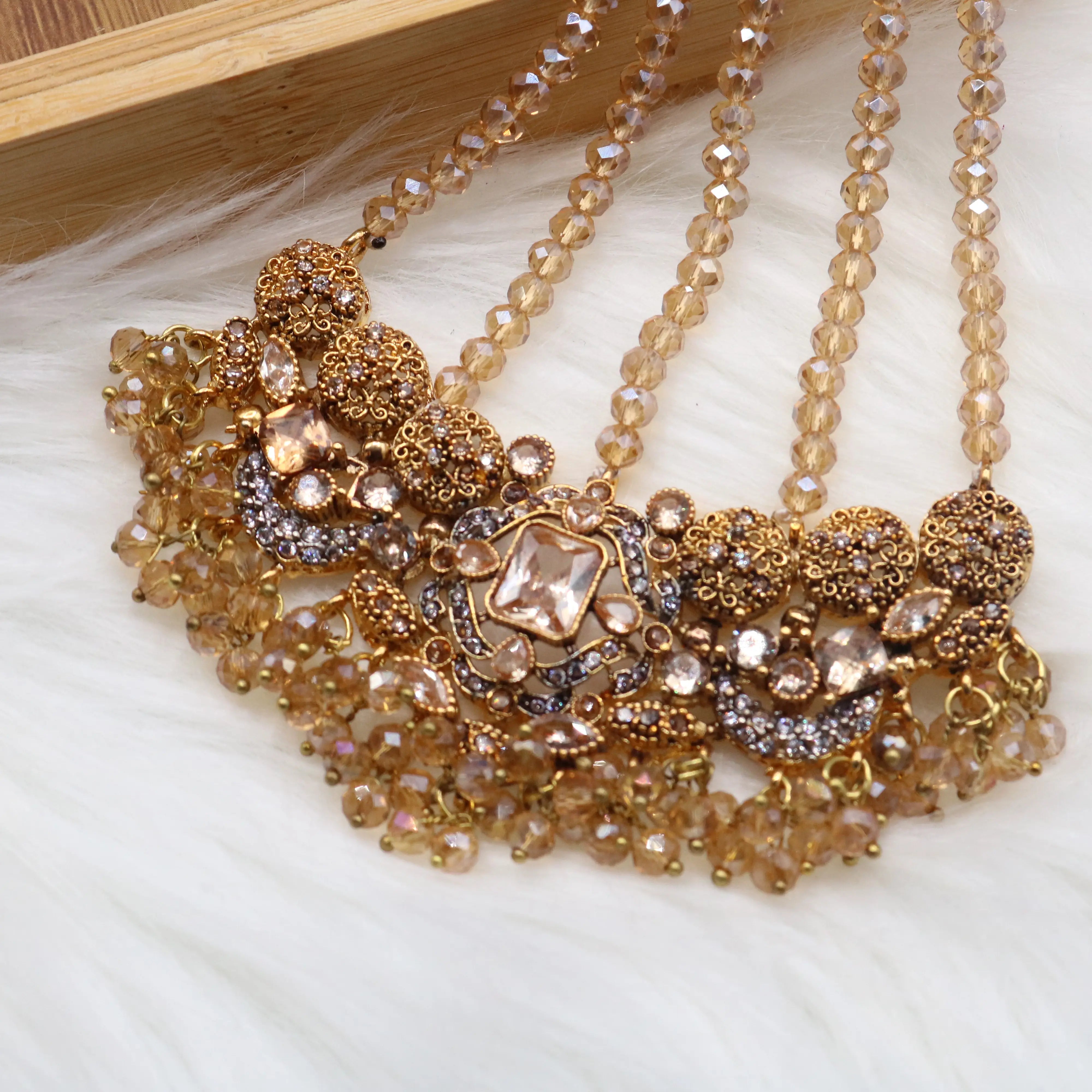 jhoomer view of Champagne gold Pakistani bridal choker jewelry set with earrings, teeka & jhoomer