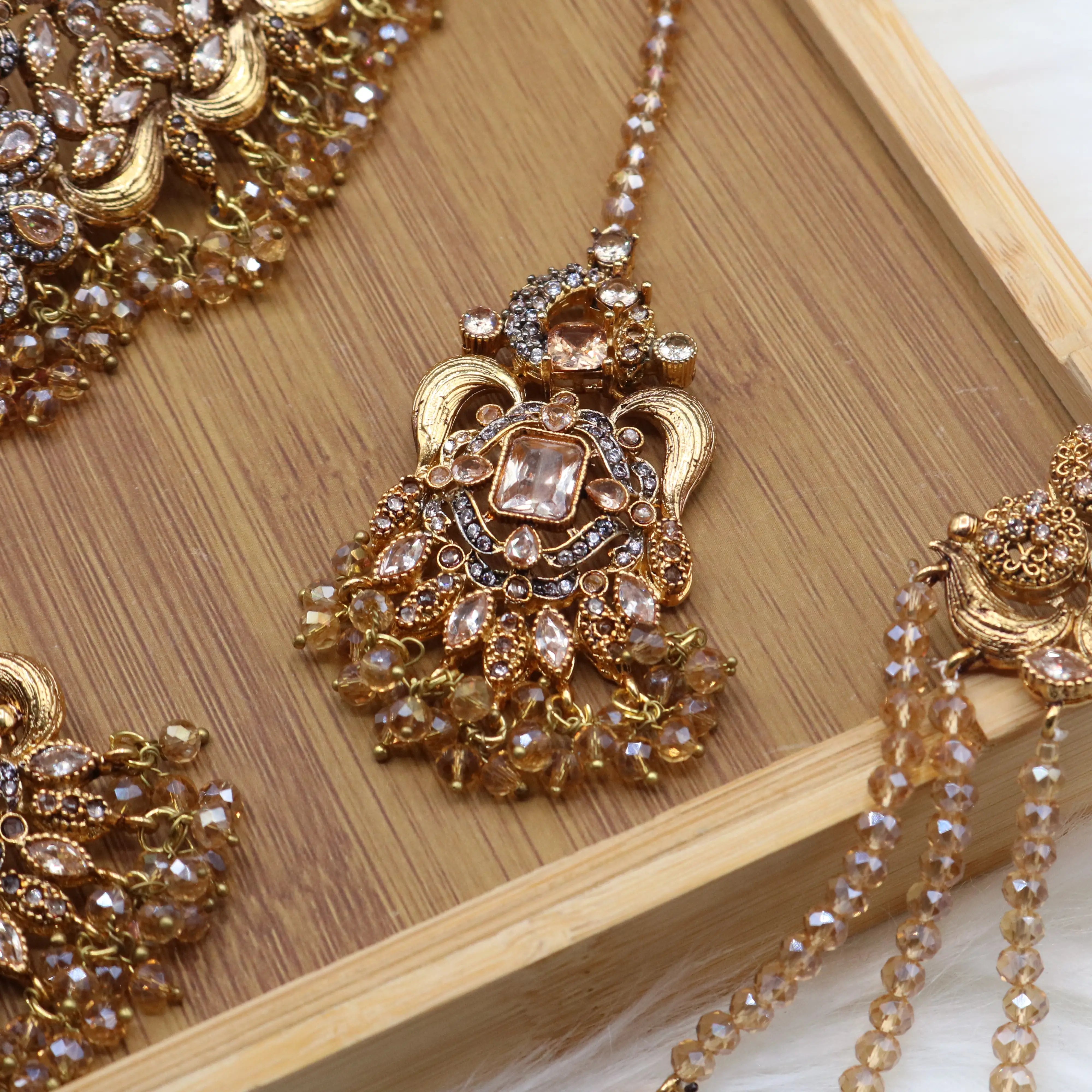 teeka view of Champagne gold Pakistani bridal choker jewelry set with earrings, teeka & jhoomer