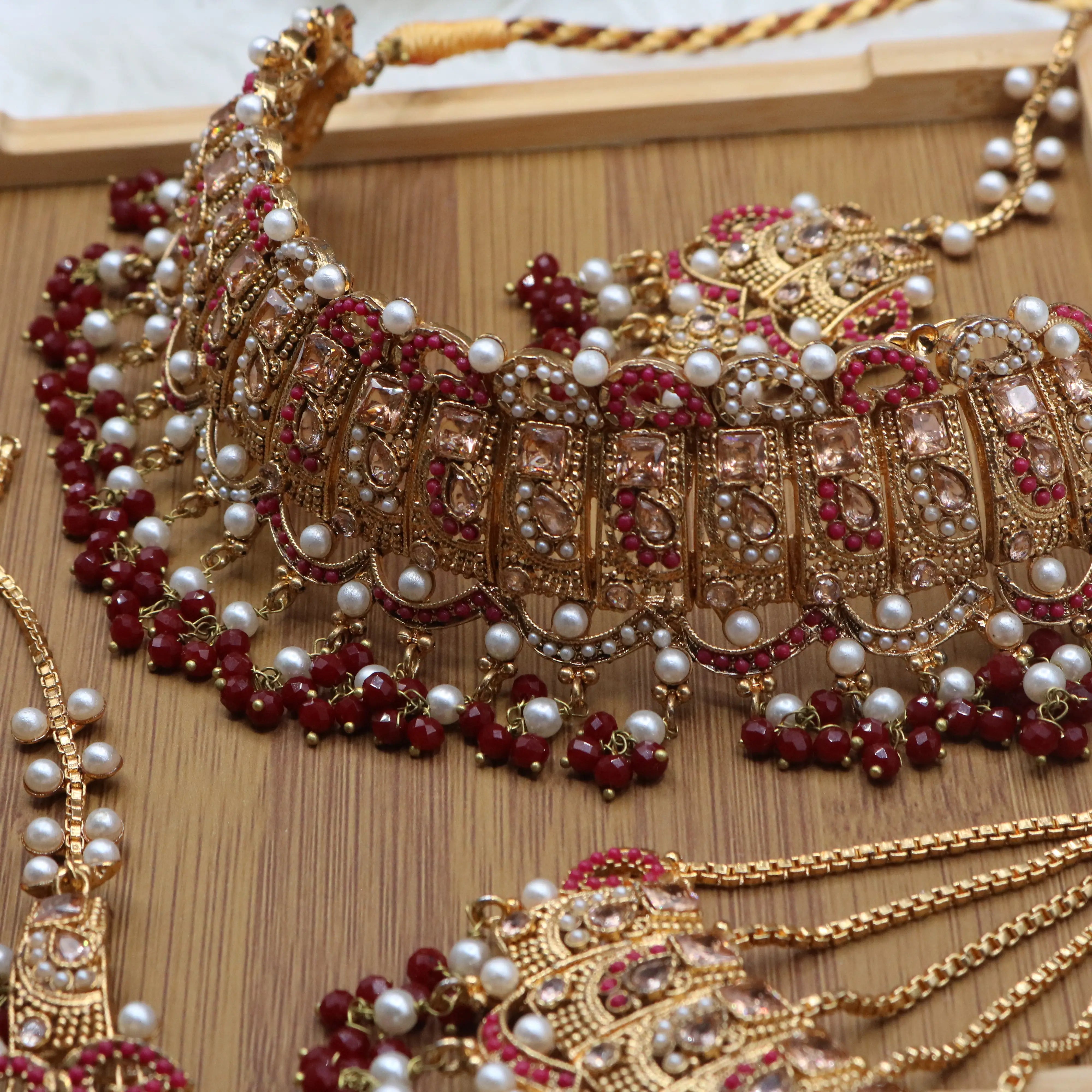 necklace view of Pakistani wedding jewelry set with choker, earrings, and jhoomer with red stones