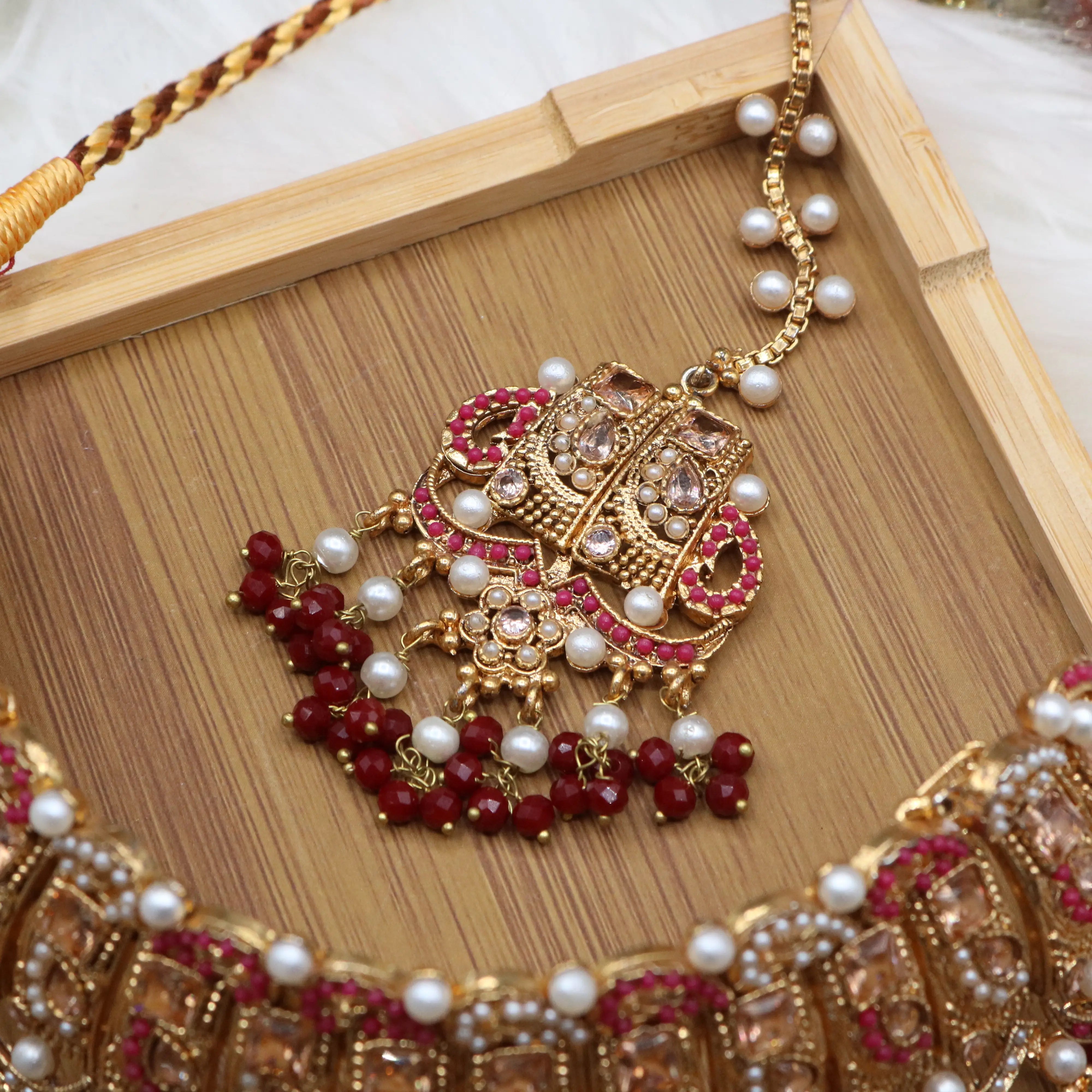 teeka view of Pakistani wedding jewelry set with choker, earrings, and jhoomer with red stones