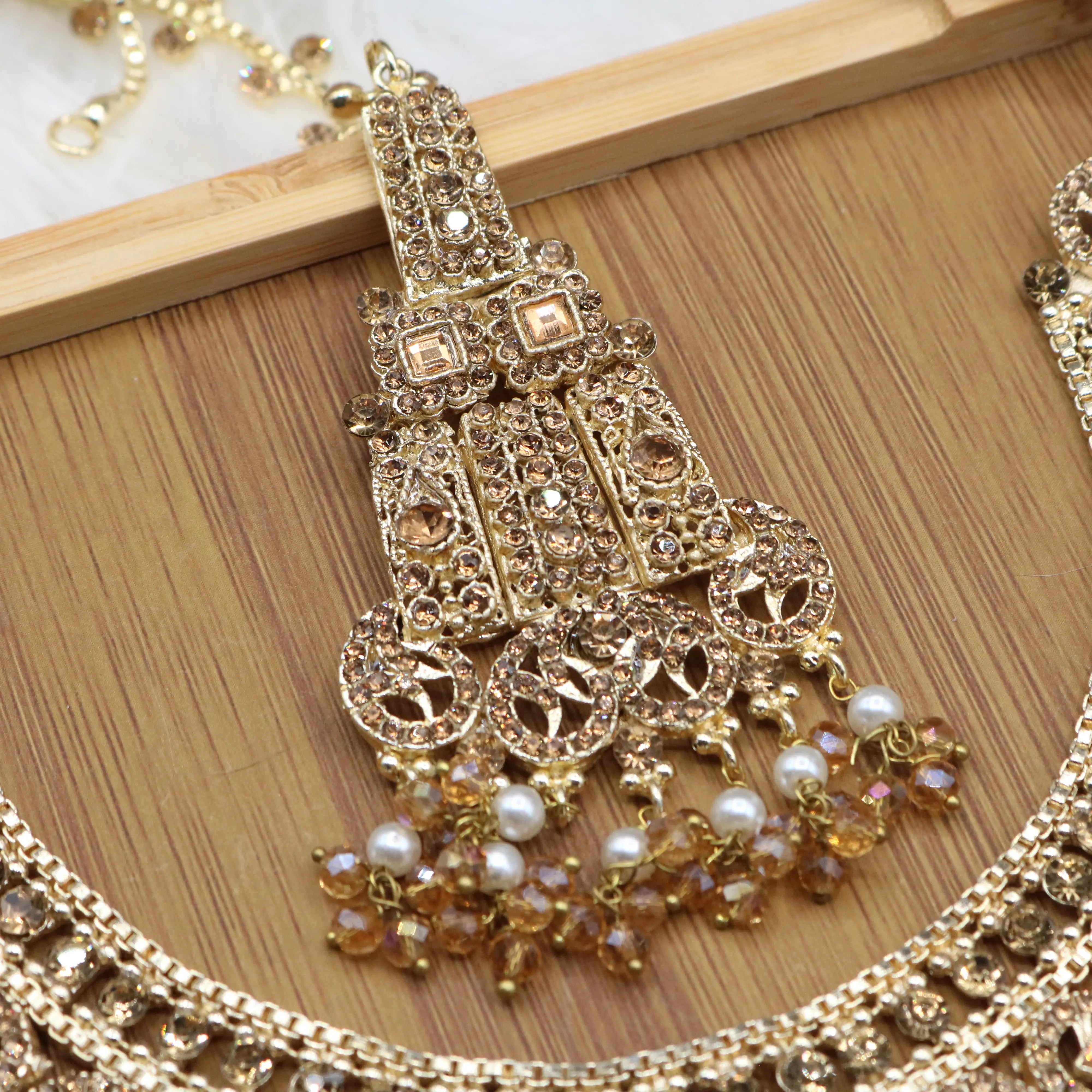 teeka view of Champagne gold Pakistani bridal necklace set with earrings, teeka & jhoomer