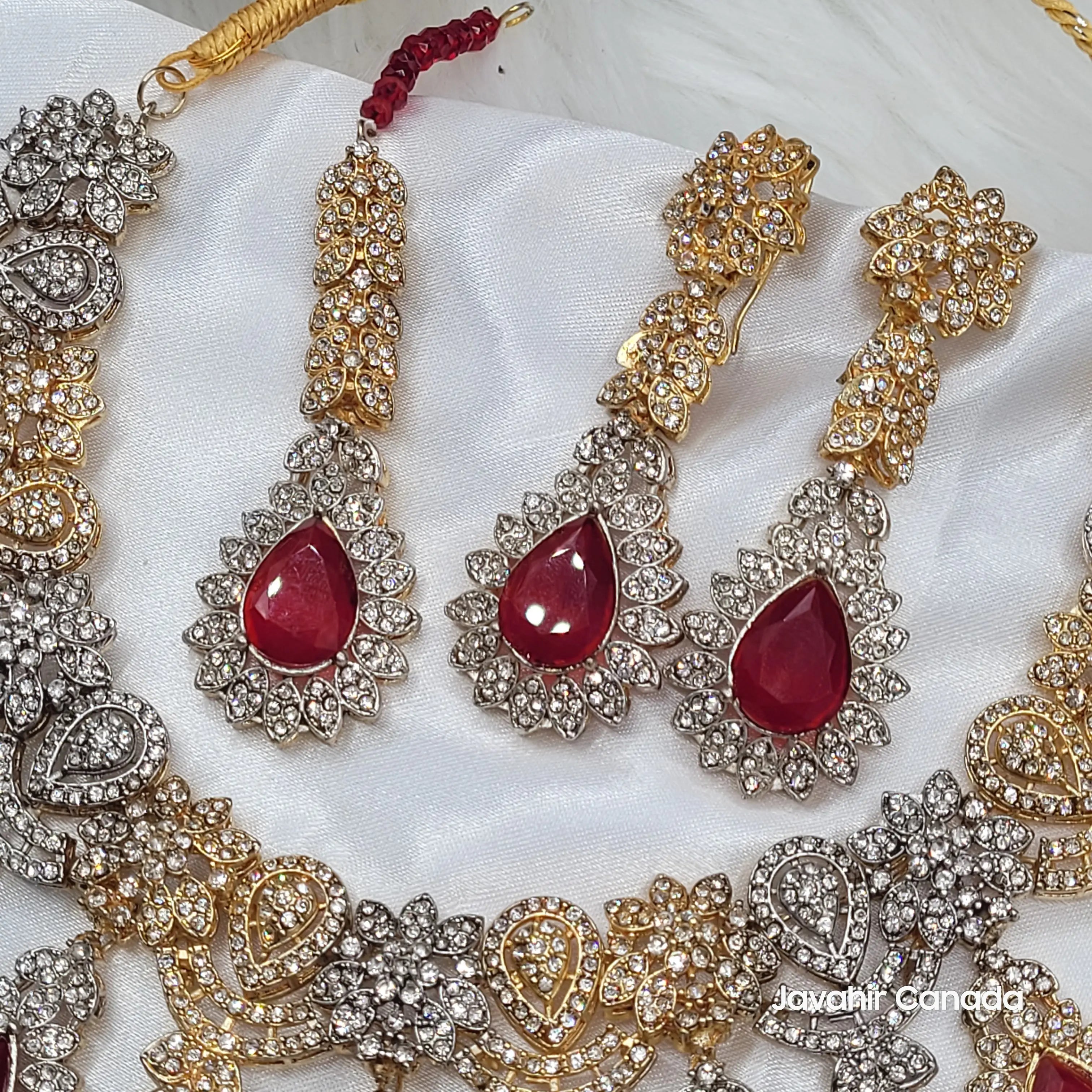Side view of JV155 earrings with long gold earrings, teeka and red center stones outlined in clear cubic zirconia.