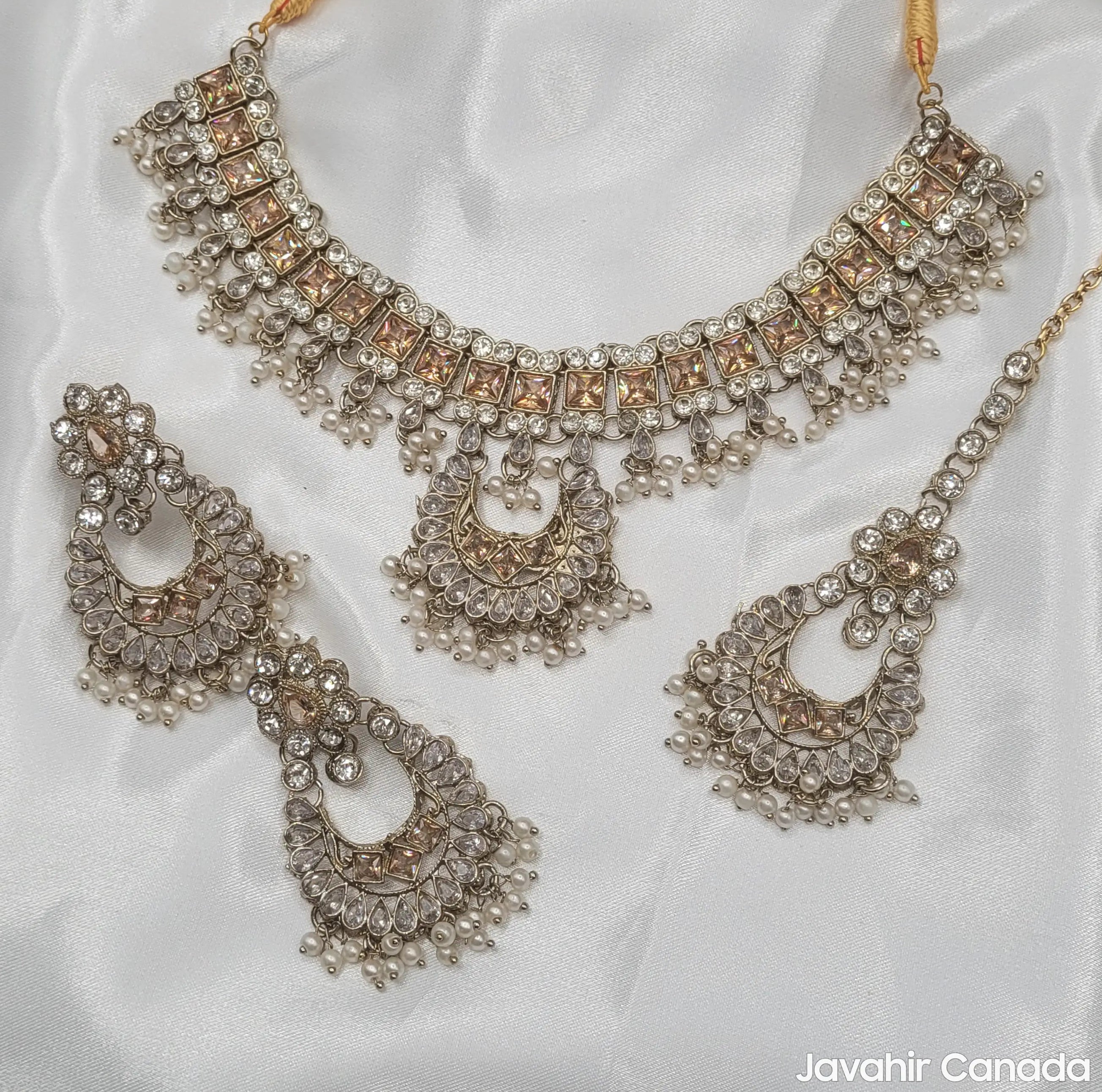 Full JV156 necklace set – including necklace, earrings, and tikka – laid on white satin.
