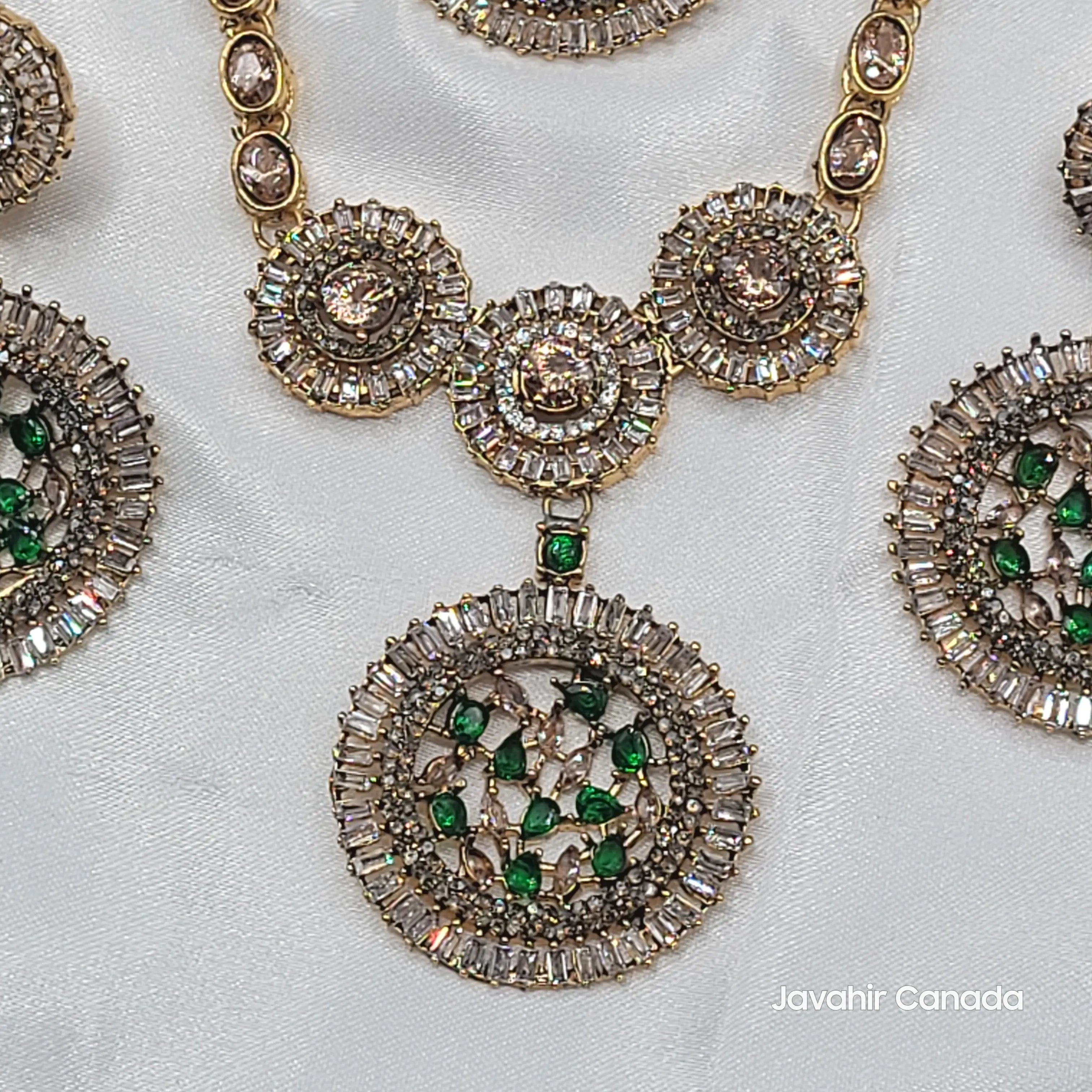 Close-up of green pendant featuring round and baguette-cut CZ with green stones