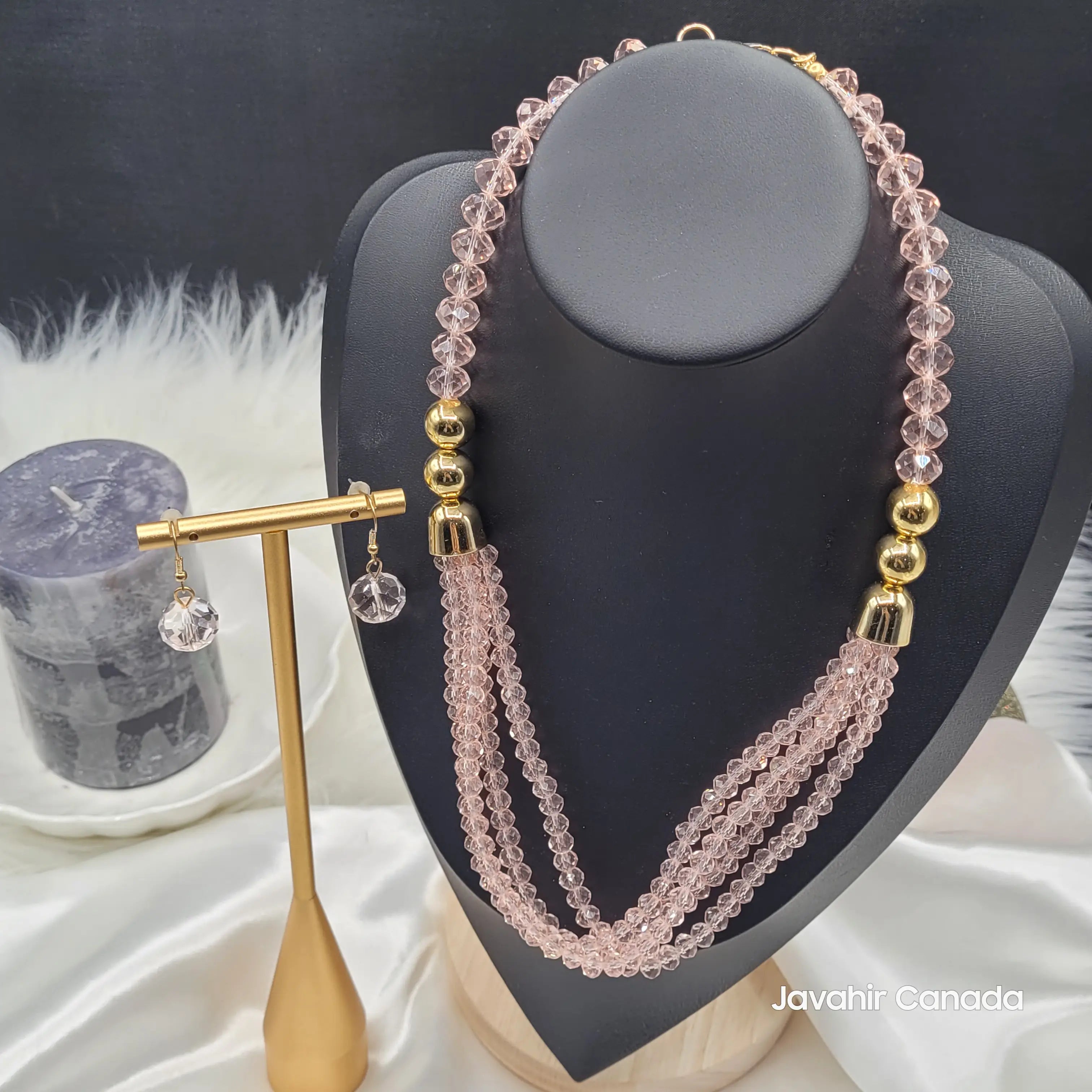 JV161 necklace set in a delicate champagne pink tone, with light pink faceted beads and gold round accents. Displayed on a black bust with matching earrings.