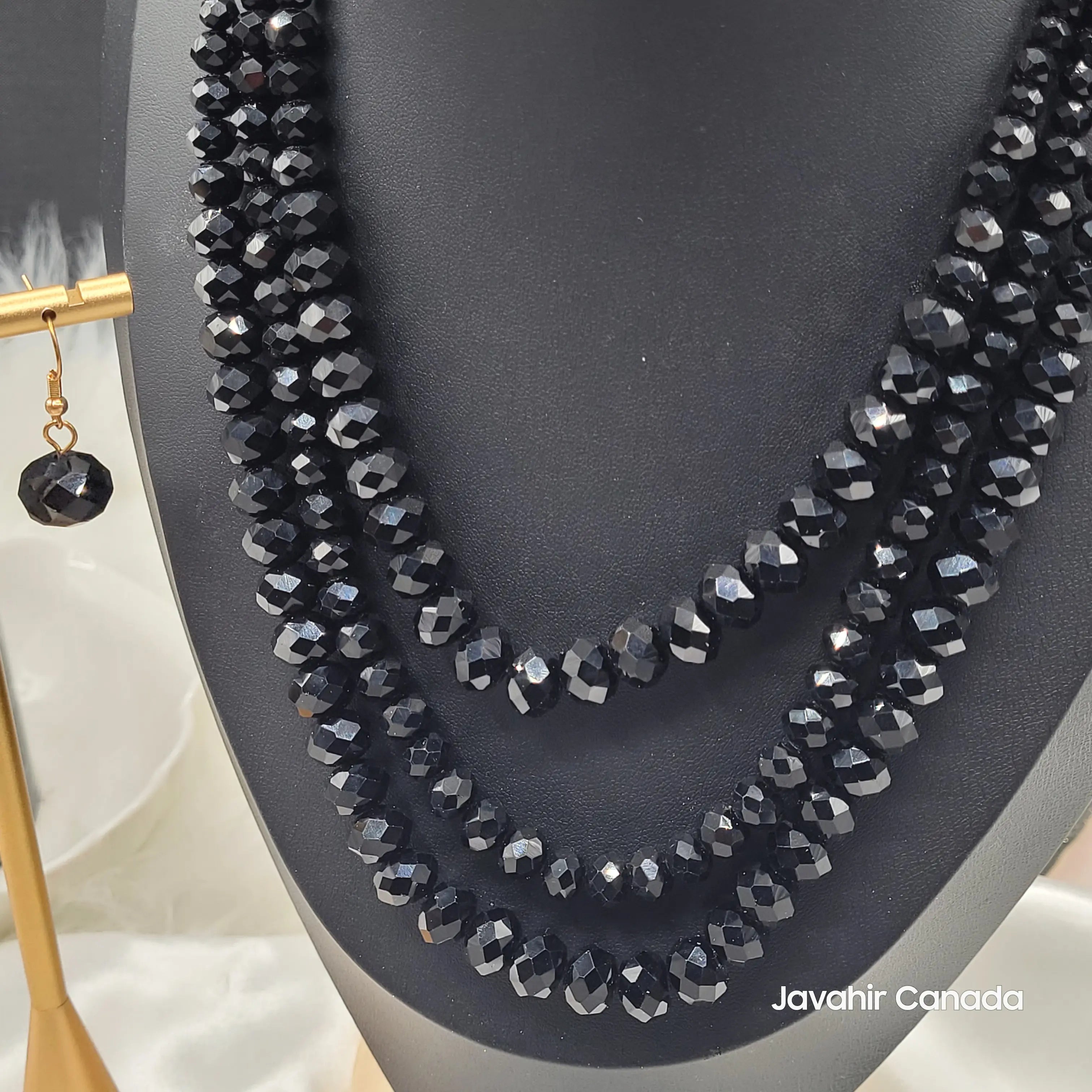 close-up of JV162 necklace set in jet black faceted glass beads with a four-strand graduated design, displayed on a black bust.