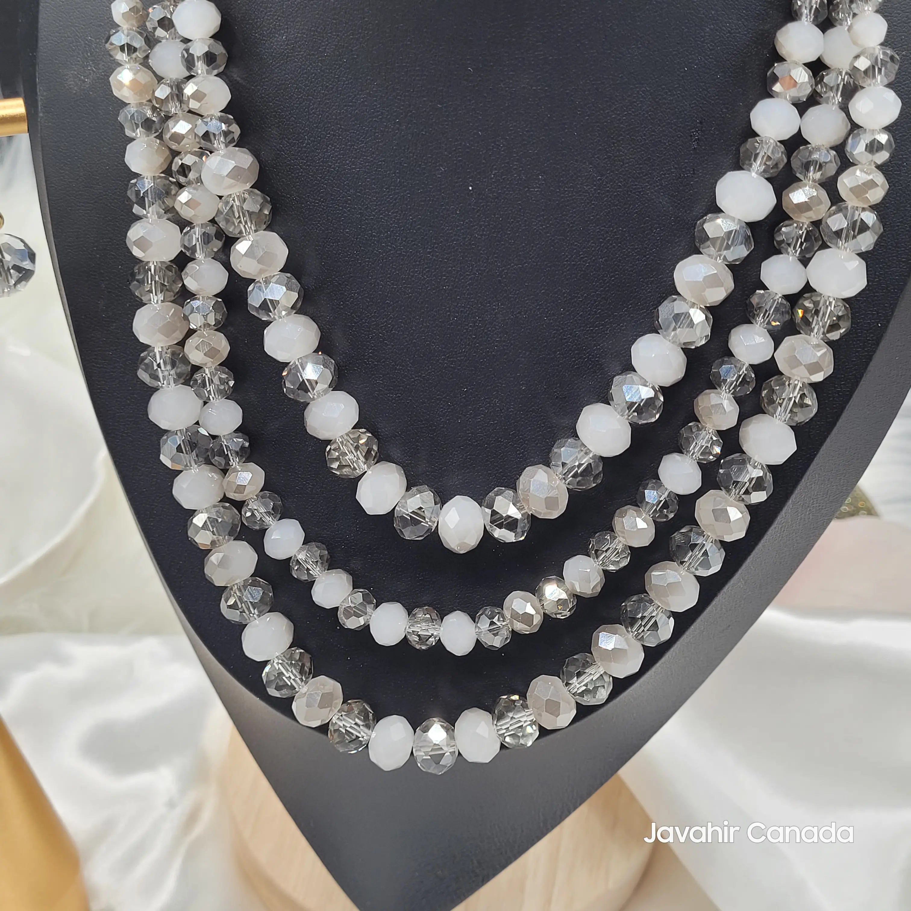 close-up of JV162 necklace featuring a four-layered design with alternating white and smoky grey faceted crystal beads