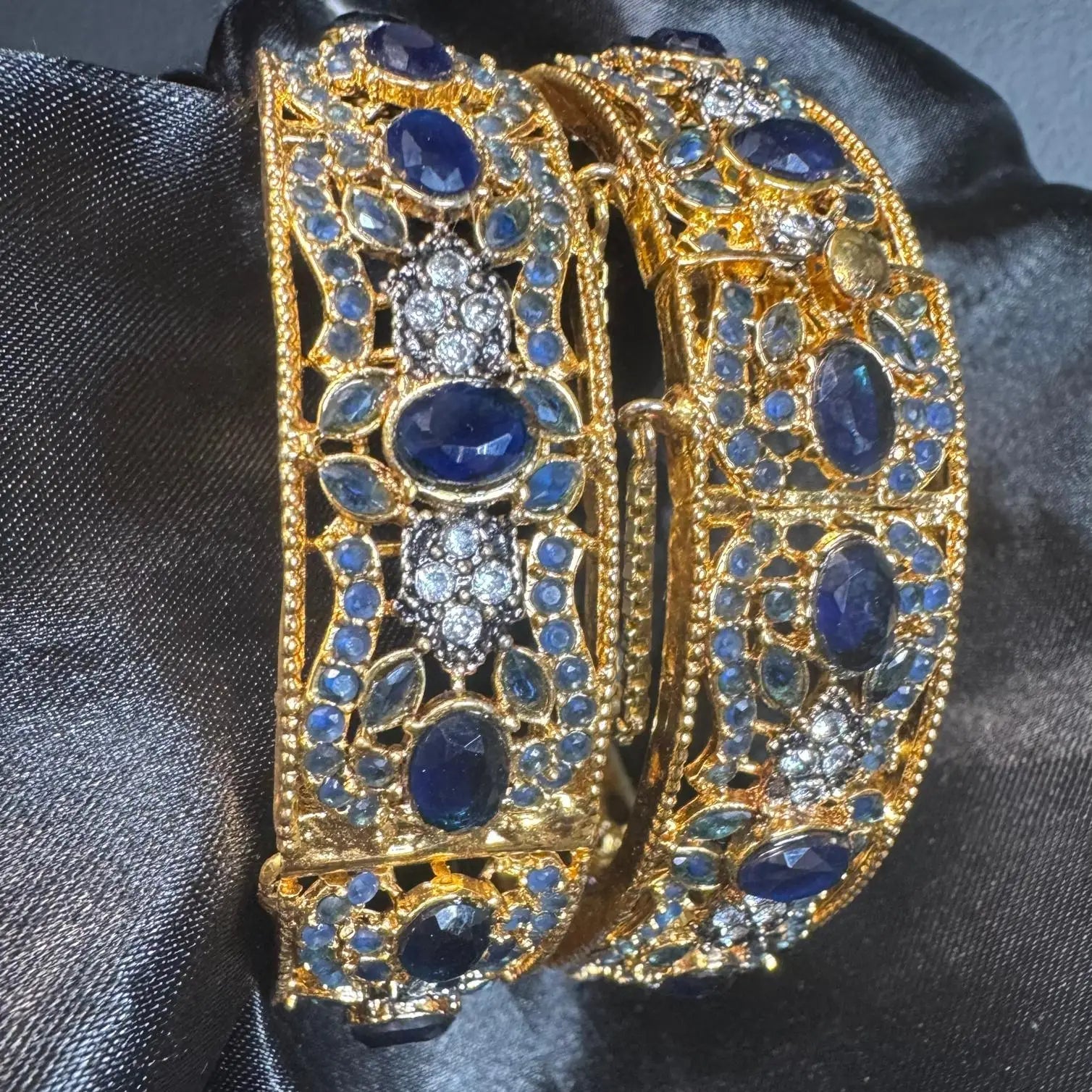 Close-up of oval and marquise sapphire stones on gold-plated bangles