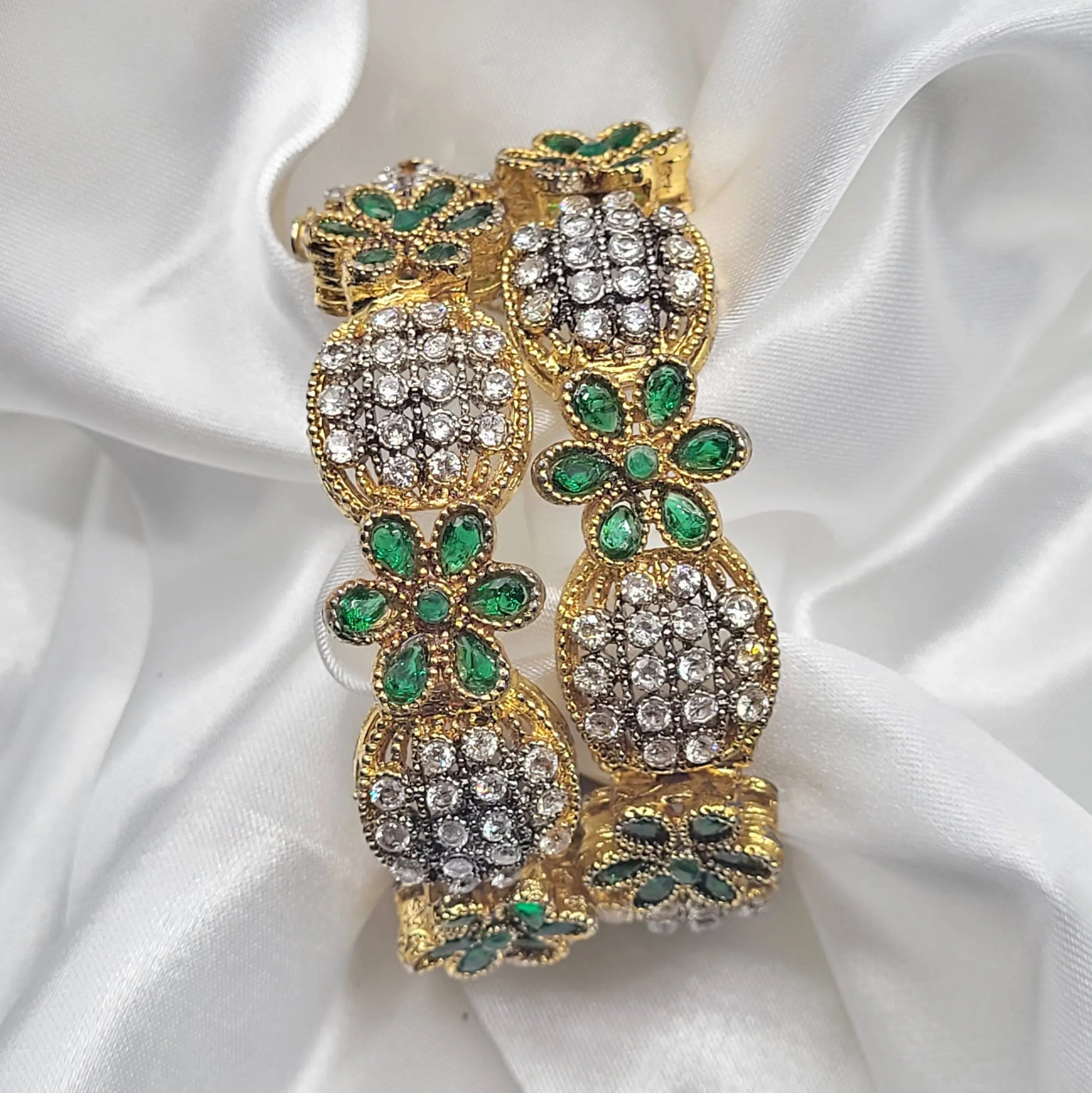 top view of Green floral crystal bangles with intricate design and clear gemstones on a white fabric background – JV3001 