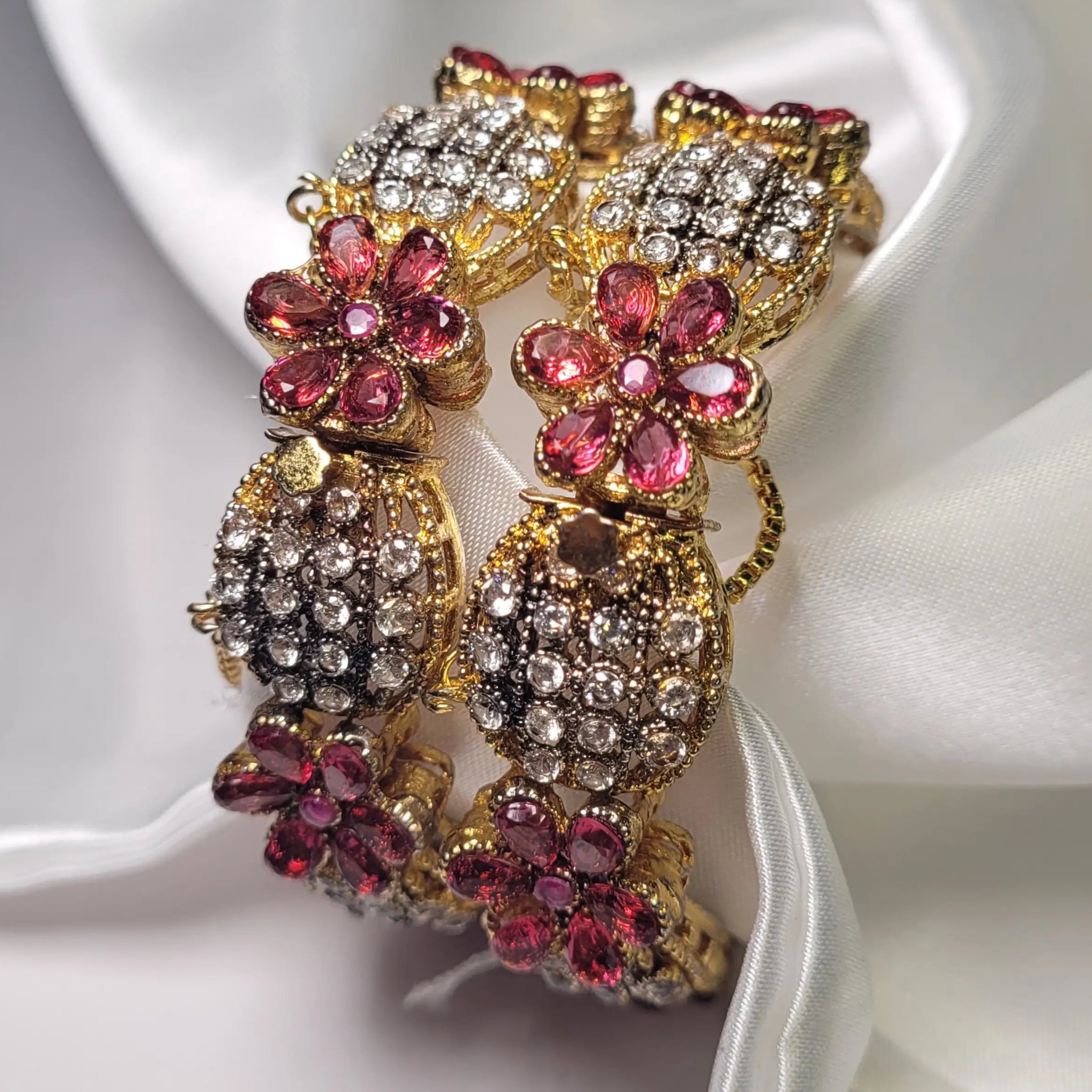 side view of Pink floral design bangles with crystals on a white fabric background – JV3001 