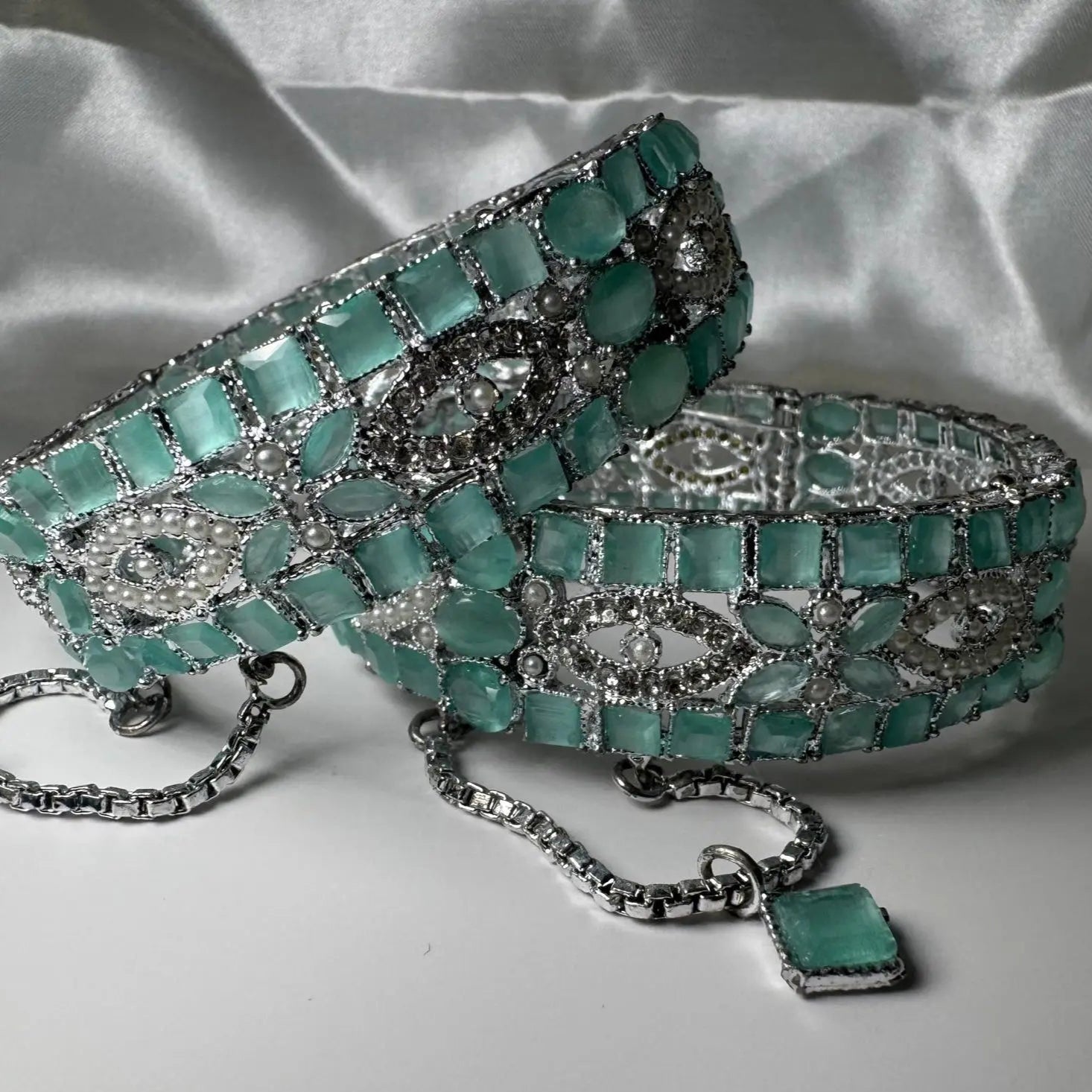Turquoise and silver bracelet on a white fabric background