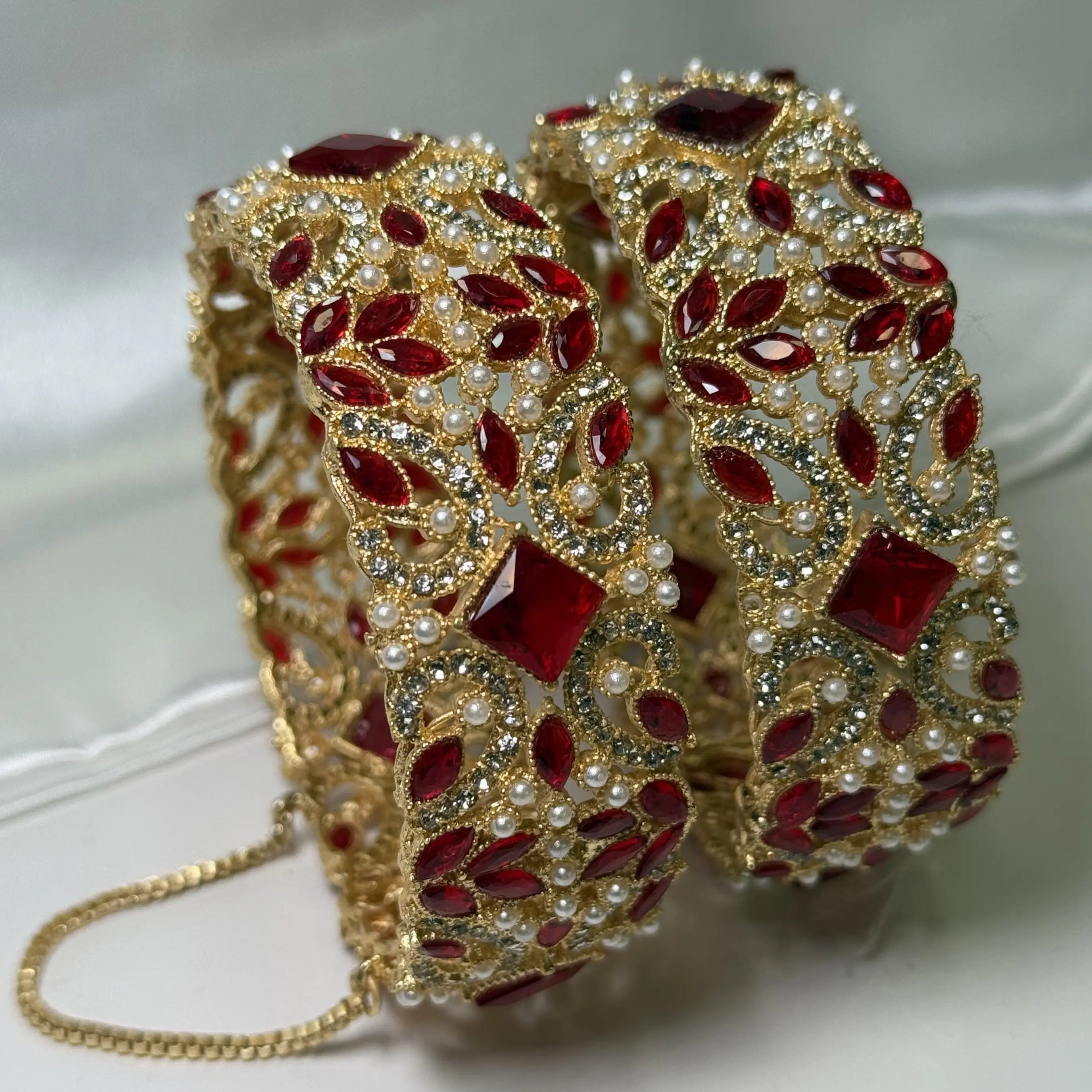 Openable traditional bangles featuring red crystals, pearls, and floral motifs