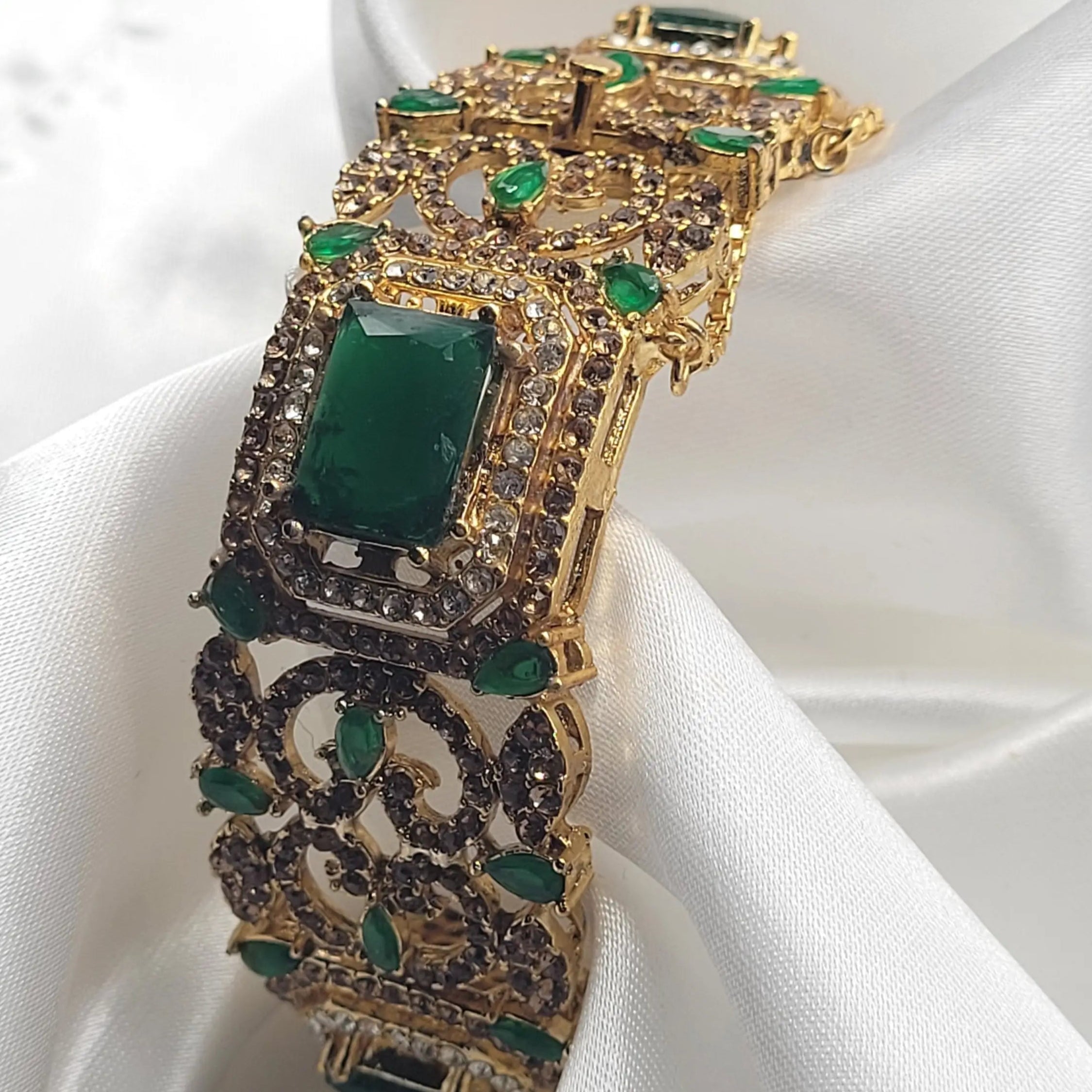 Statement bangle with emerald stones and vintage pattern – close-up