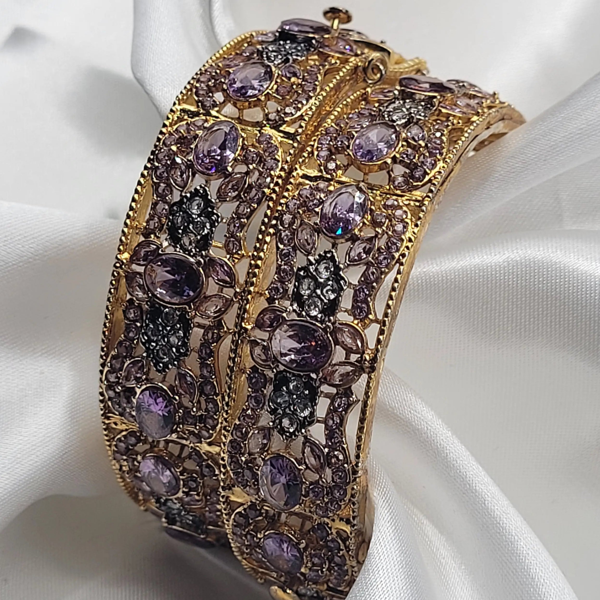 Floral pattern gold bangles with lavender and black accents – close-up