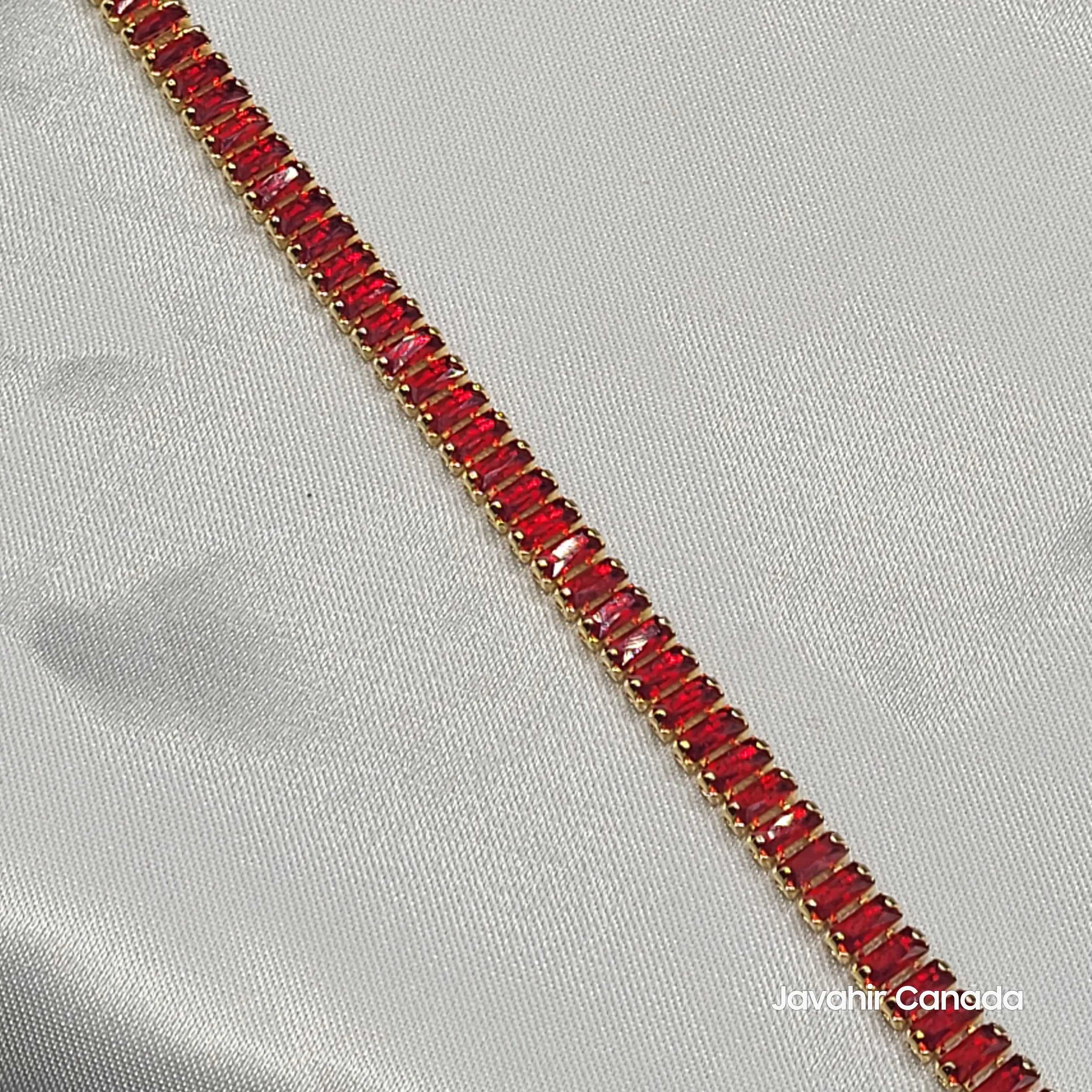 Close-up of red CZ stones in gold-tone setting – JV4004 bracelet