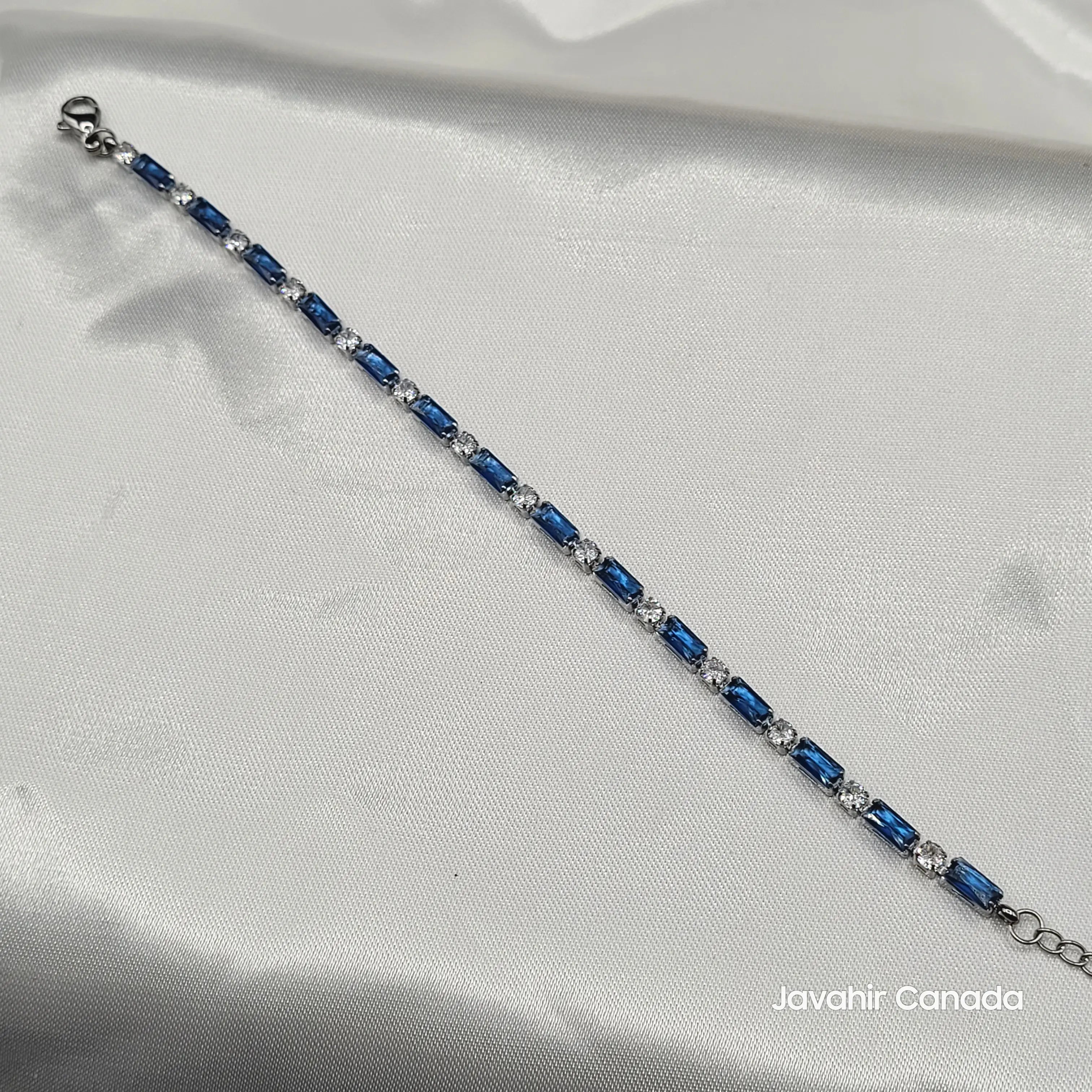JV4009 bracelet featuring blue baguette and clear round stones in silver-tone setting on satin